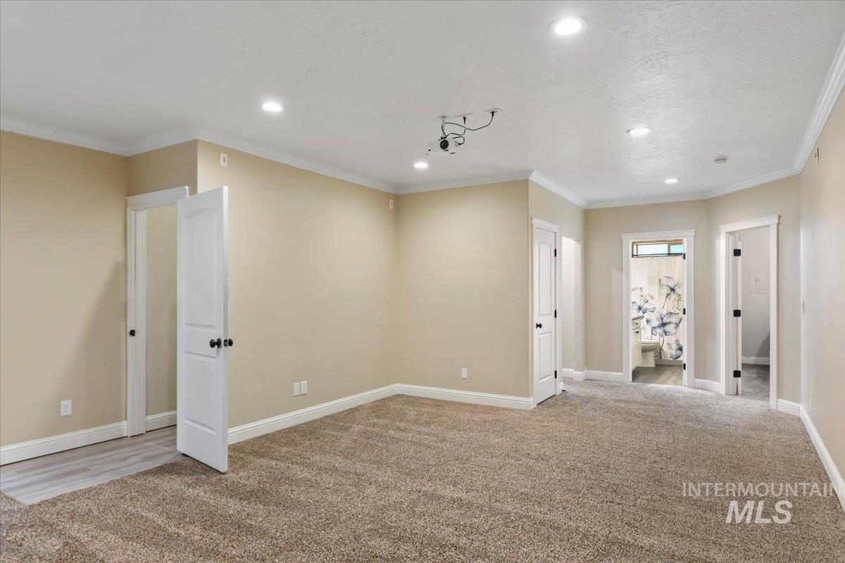 Unfurnished room featuring crown molding, light carpet, and recessed lighting