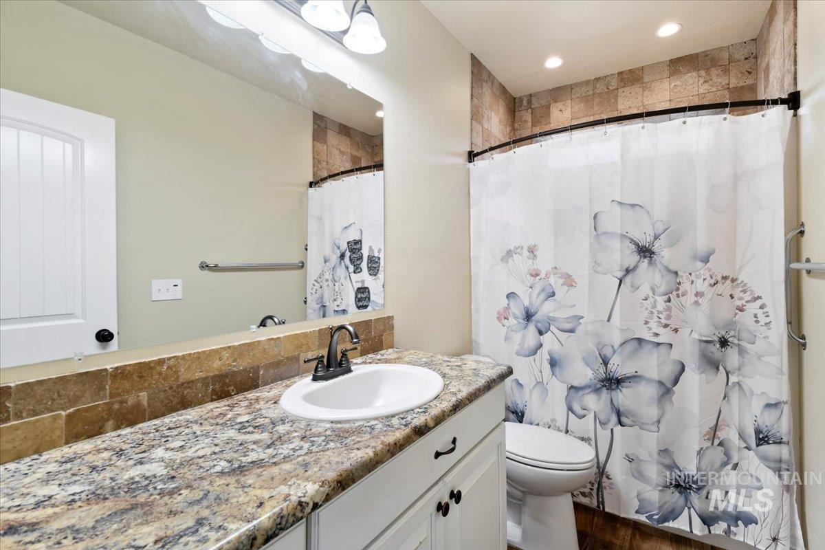 Full bathroom featuring vanity, a shower with shower curtain, and recessed lighting