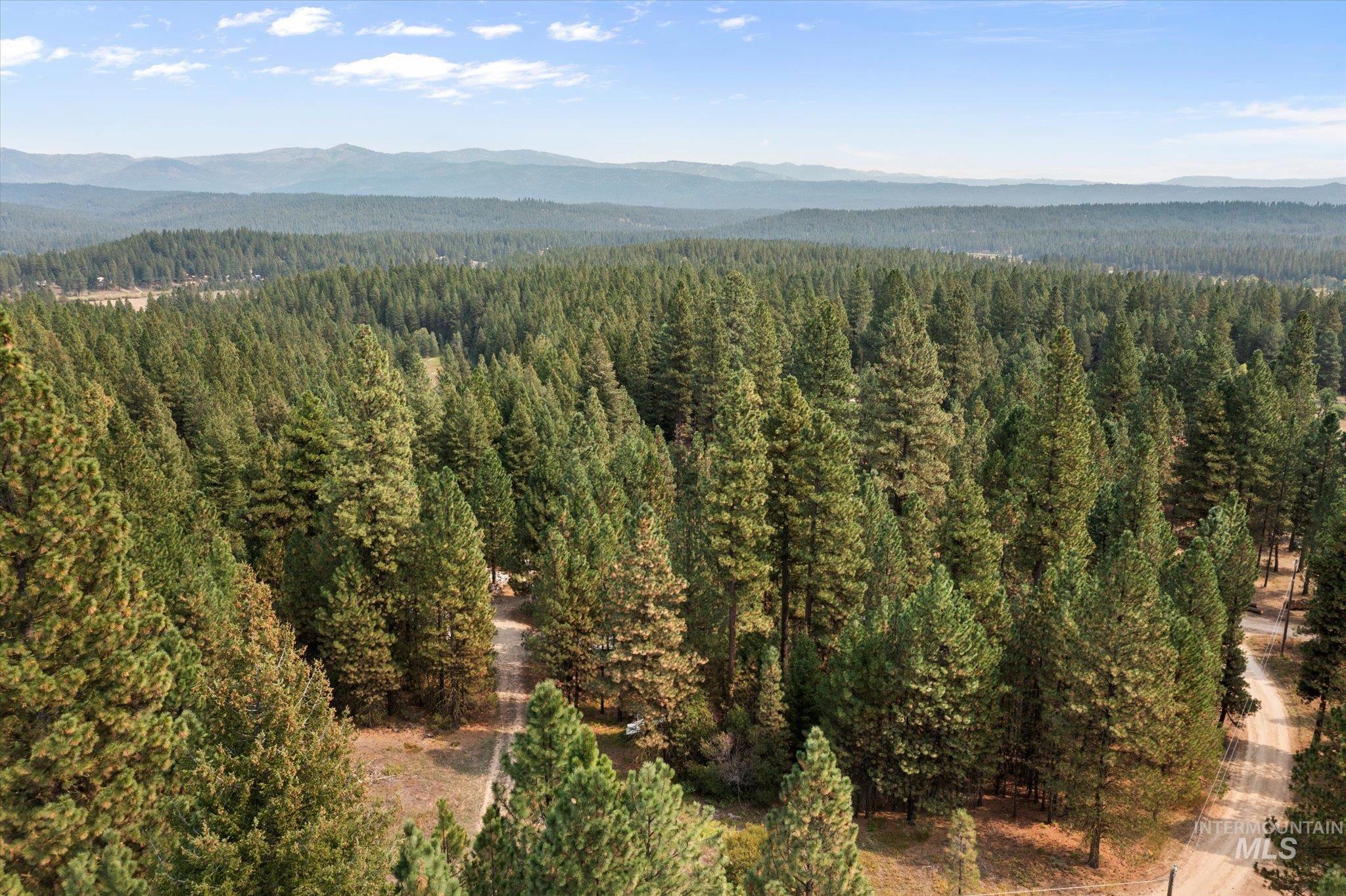 Aerial view of property and surrounding area featuring mountains