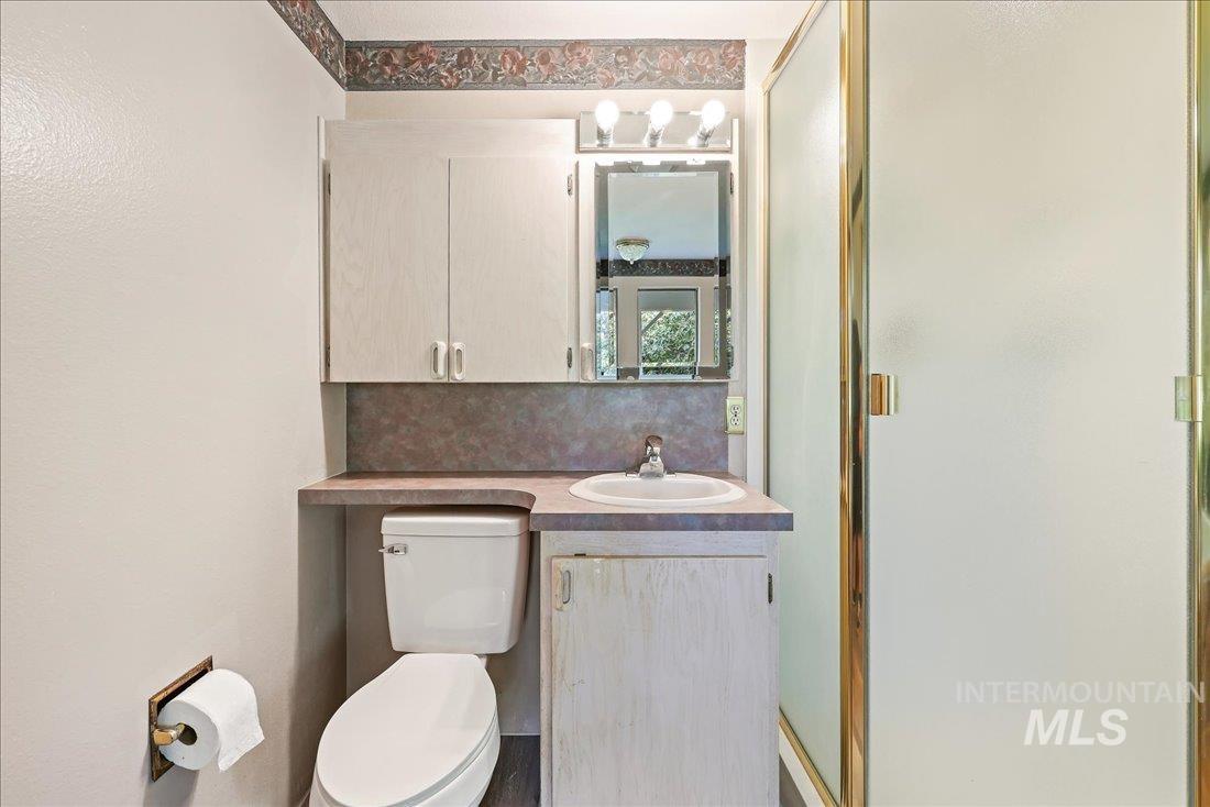 Bathroom featuring vanity, a shower stall, and decorative backsplash