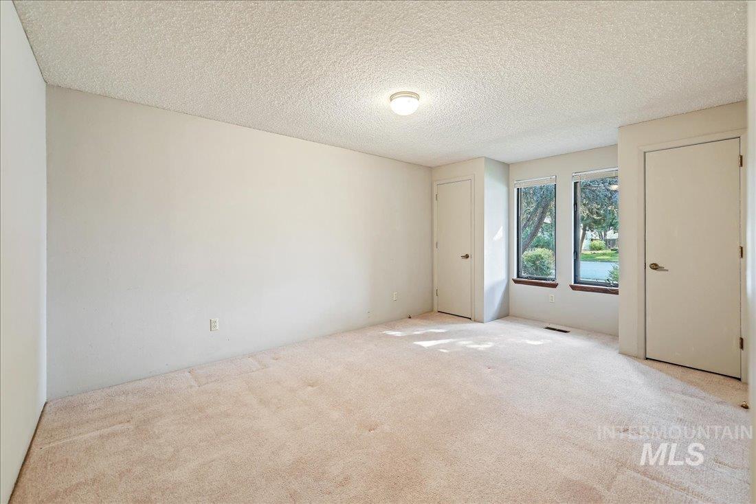 Unfurnished room featuring carpet and a textured ceiling