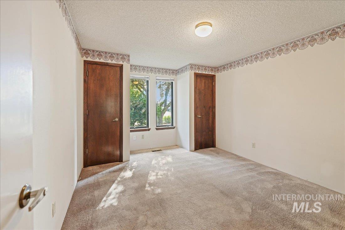 Unfurnished bedroom with carpet and a textured ceiling