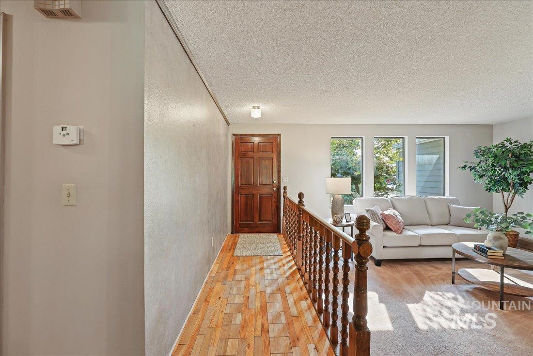 Hall with light wood-style floors and a textured ceiling