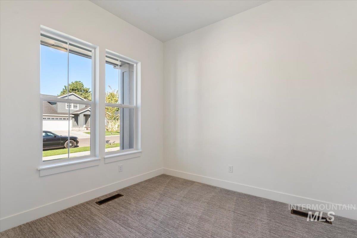 Carpeted spare room with baseboards