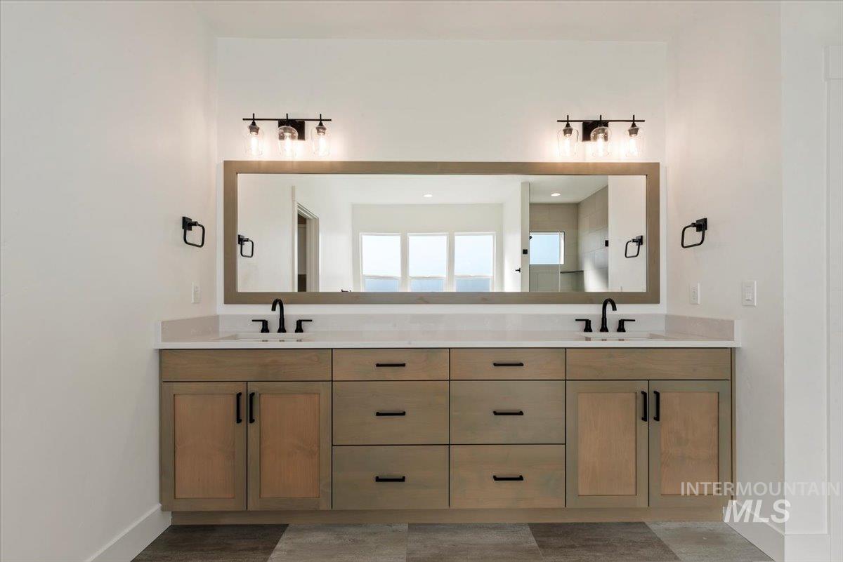 Full bath with double vanity and baseboards