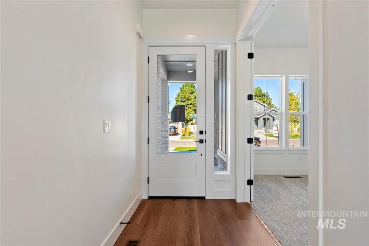 Doorway featuring wood finished floors and baseboards