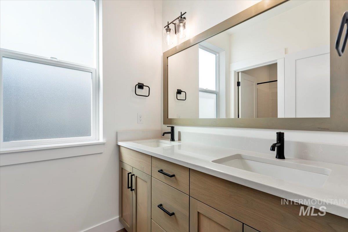 Bathroom with double vanity and baseboards