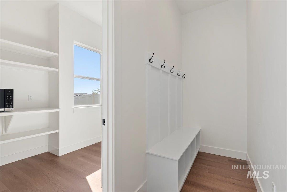 Mudroom with dark wood finished floors and baseboards