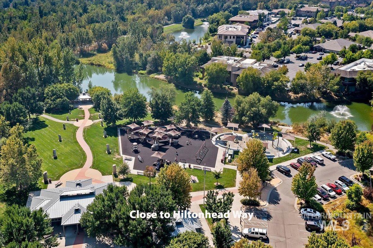 Aerial view of property and surrounding area featuring a nearby body of water and nearby suburban area