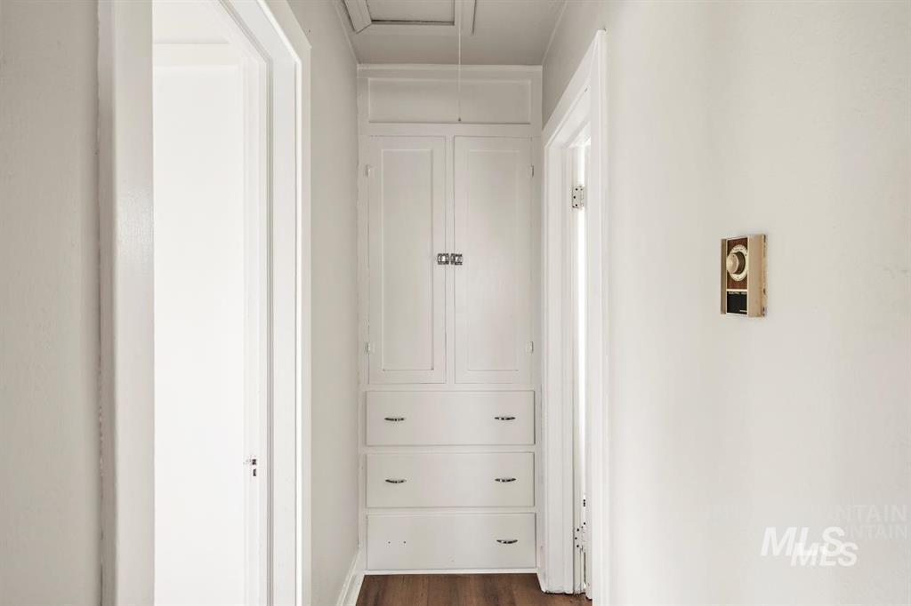 Hallway featuring dark wood finished floors and baseboards