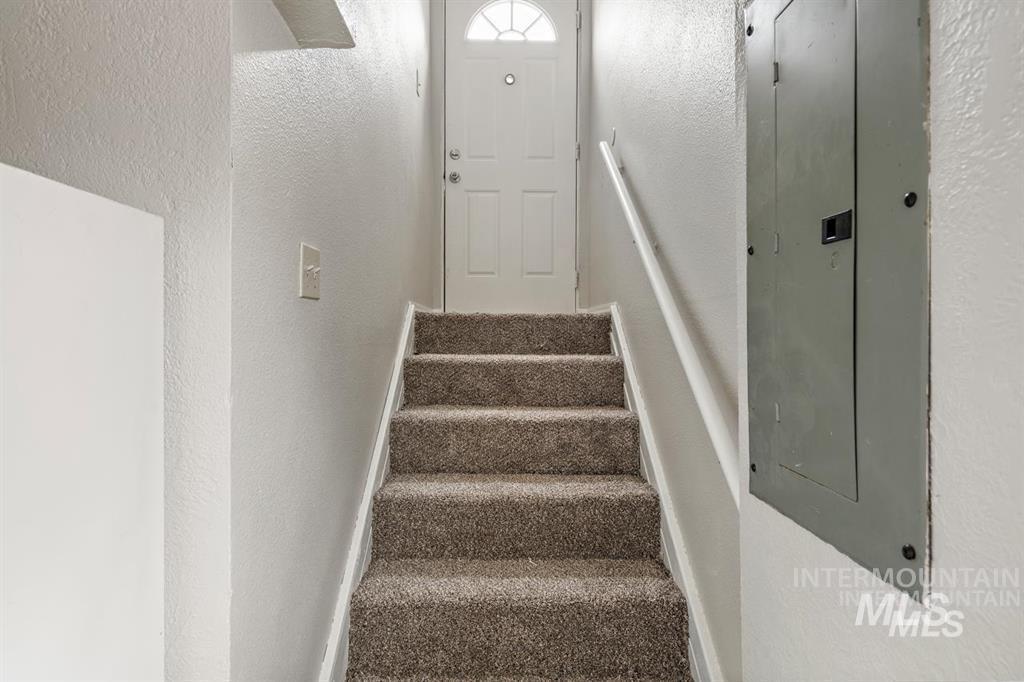 Staircase with a textured wall and electric panel