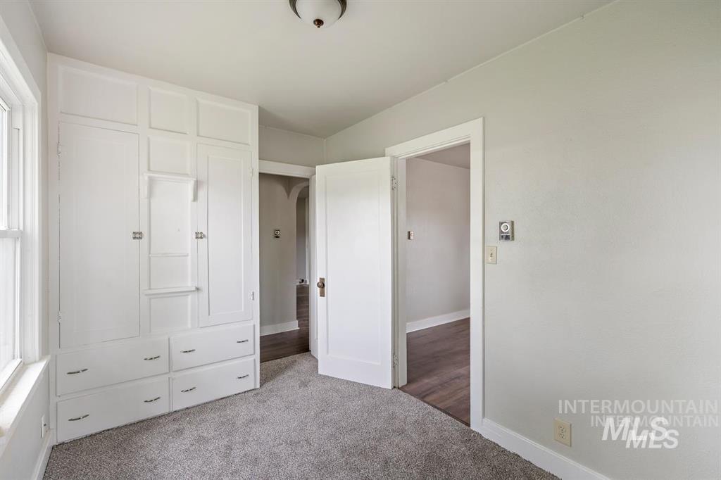 Unfurnished bedroom with carpet floors and baseboards