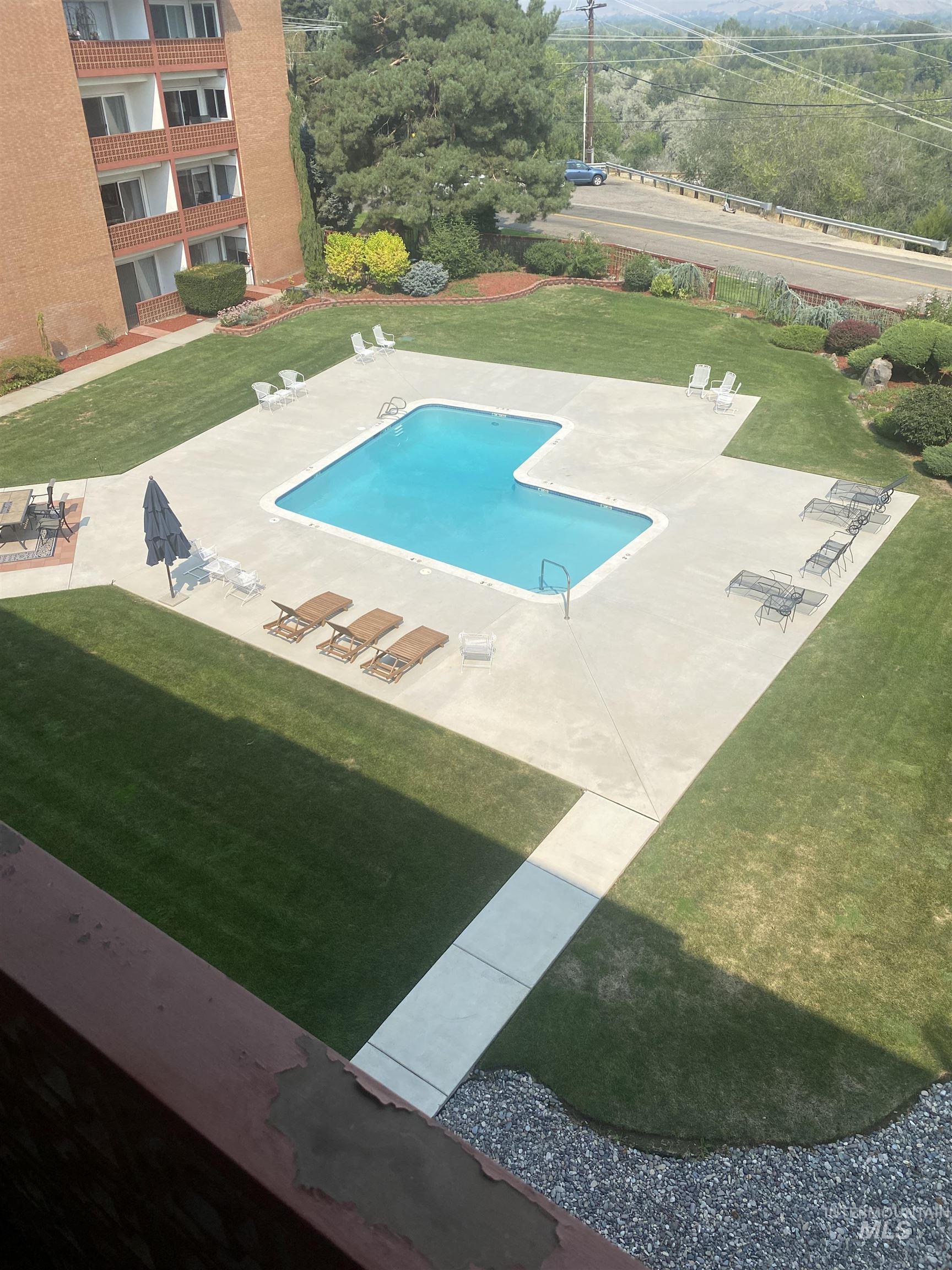 Community pool featuring a patio and a yard