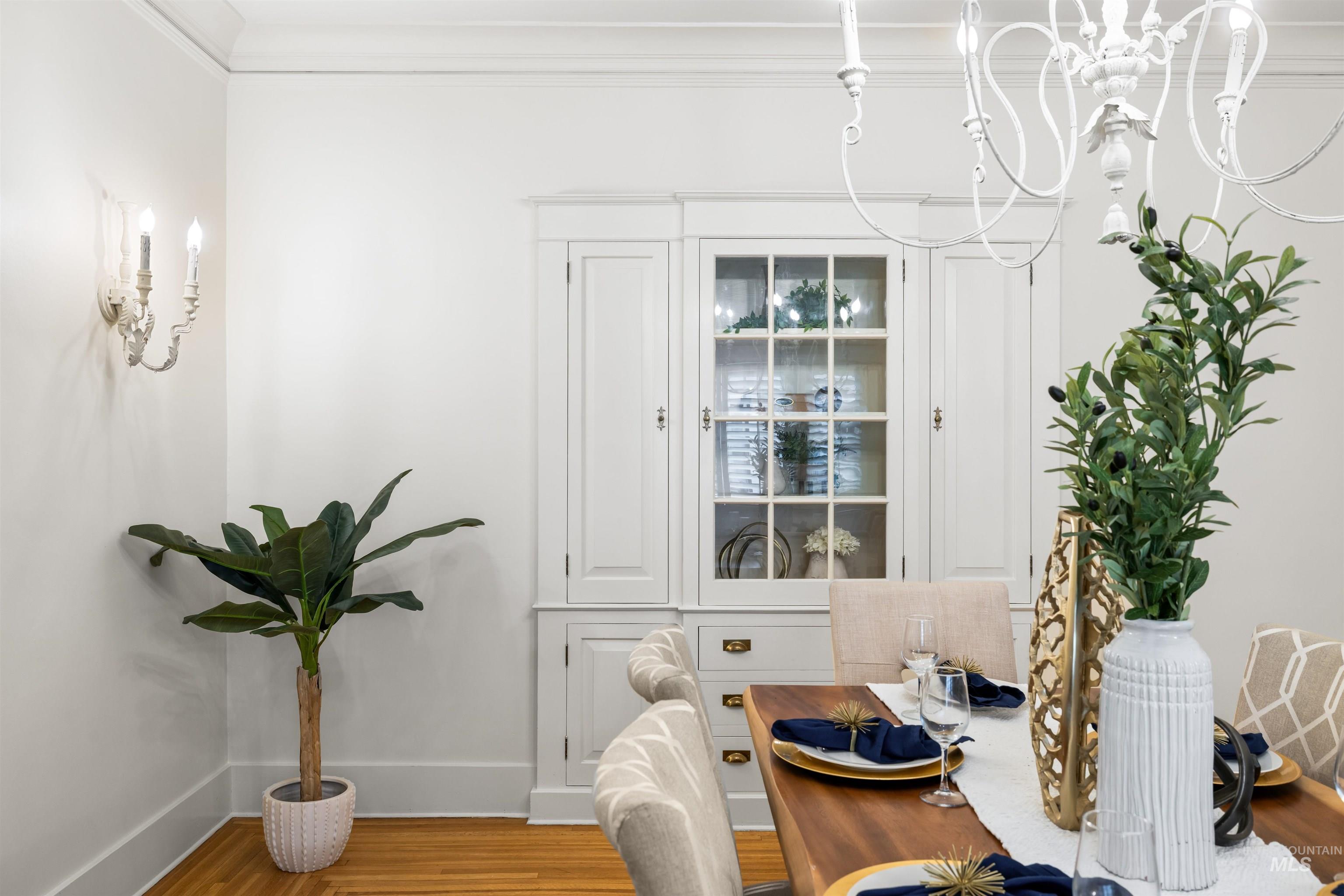 Dining room with wood finished floors and crown molding