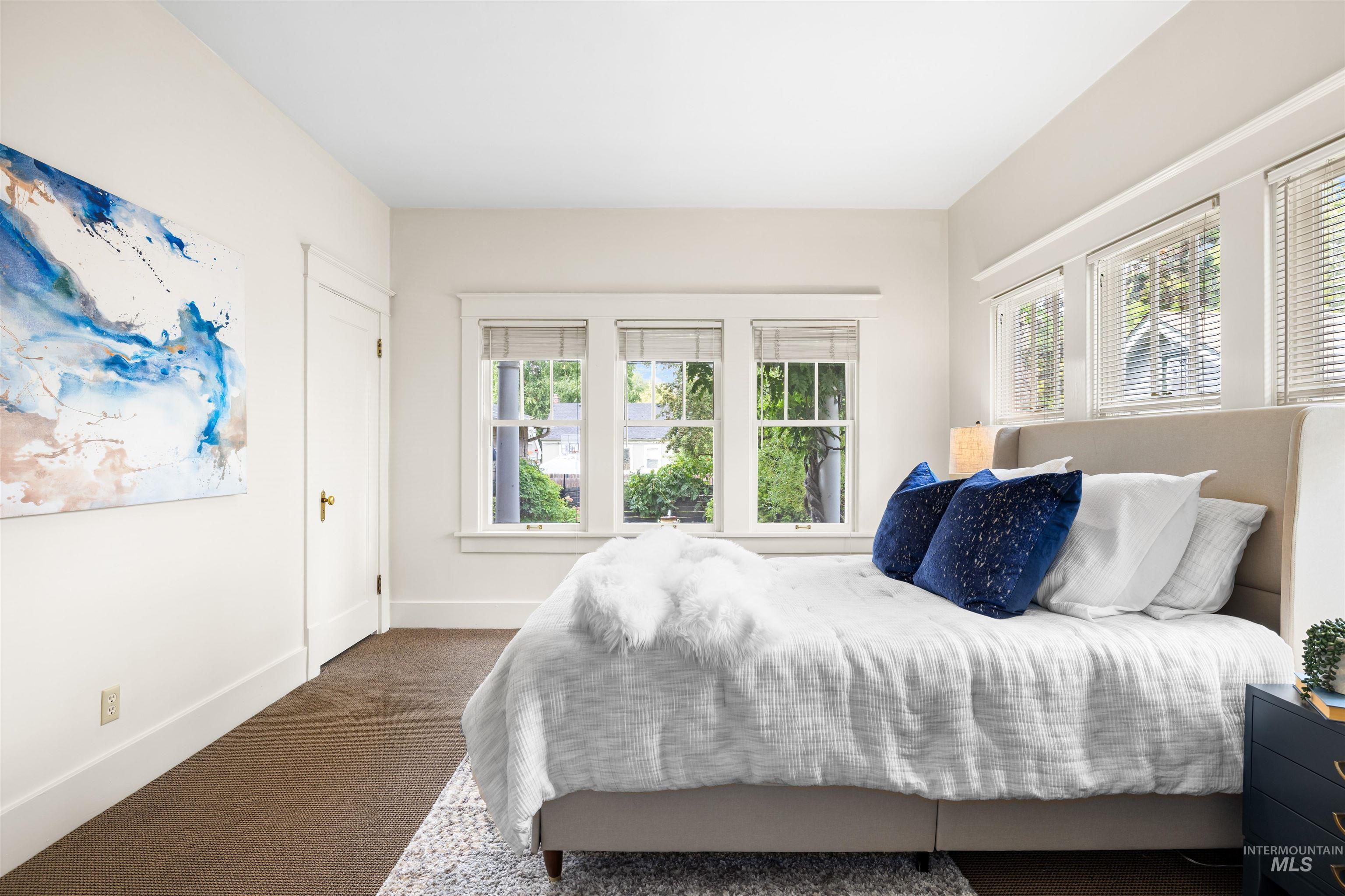 Bedroom featuring multiple windows and carpet flooring