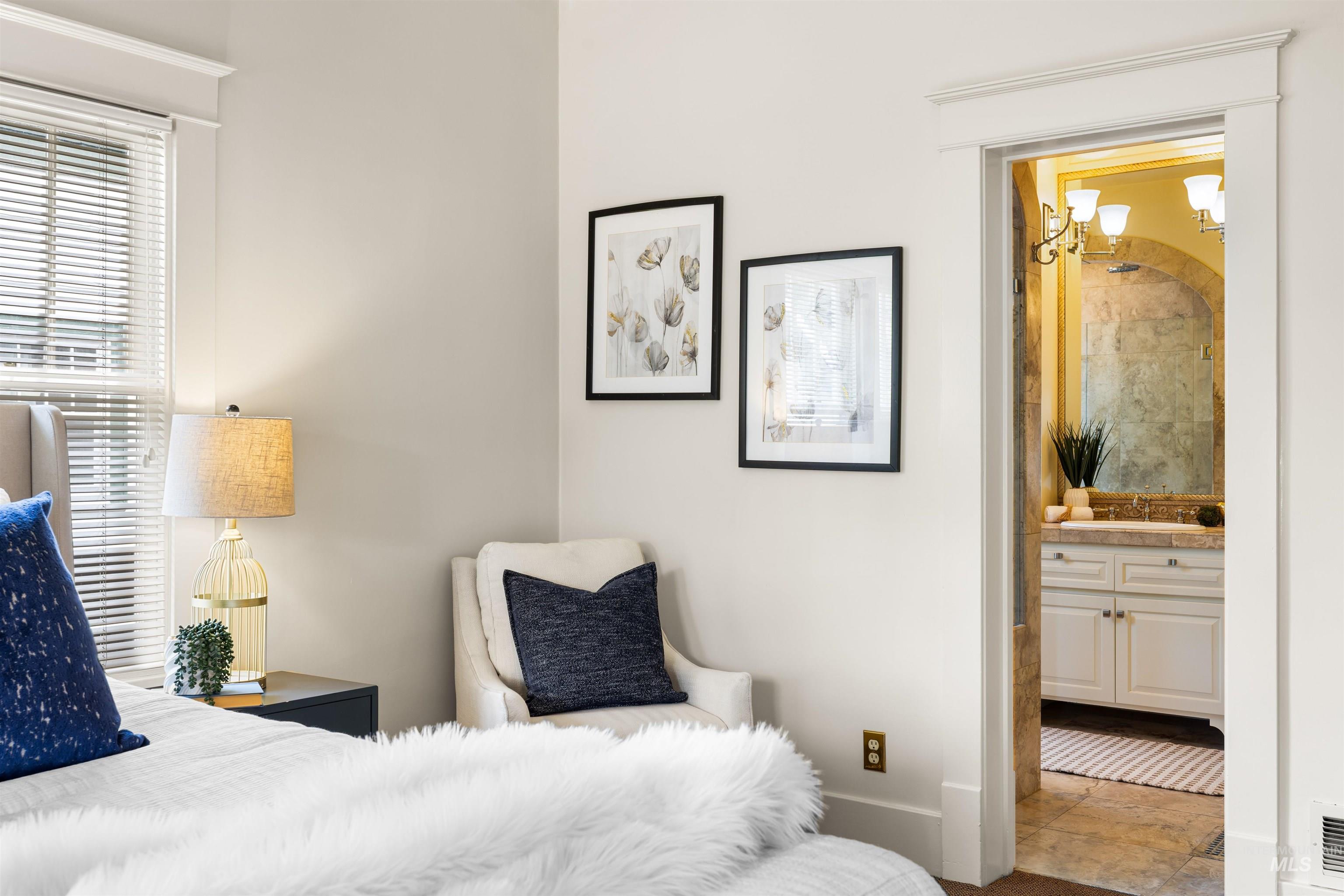 Bedroom featuring ensuite bathroom and baseboards
