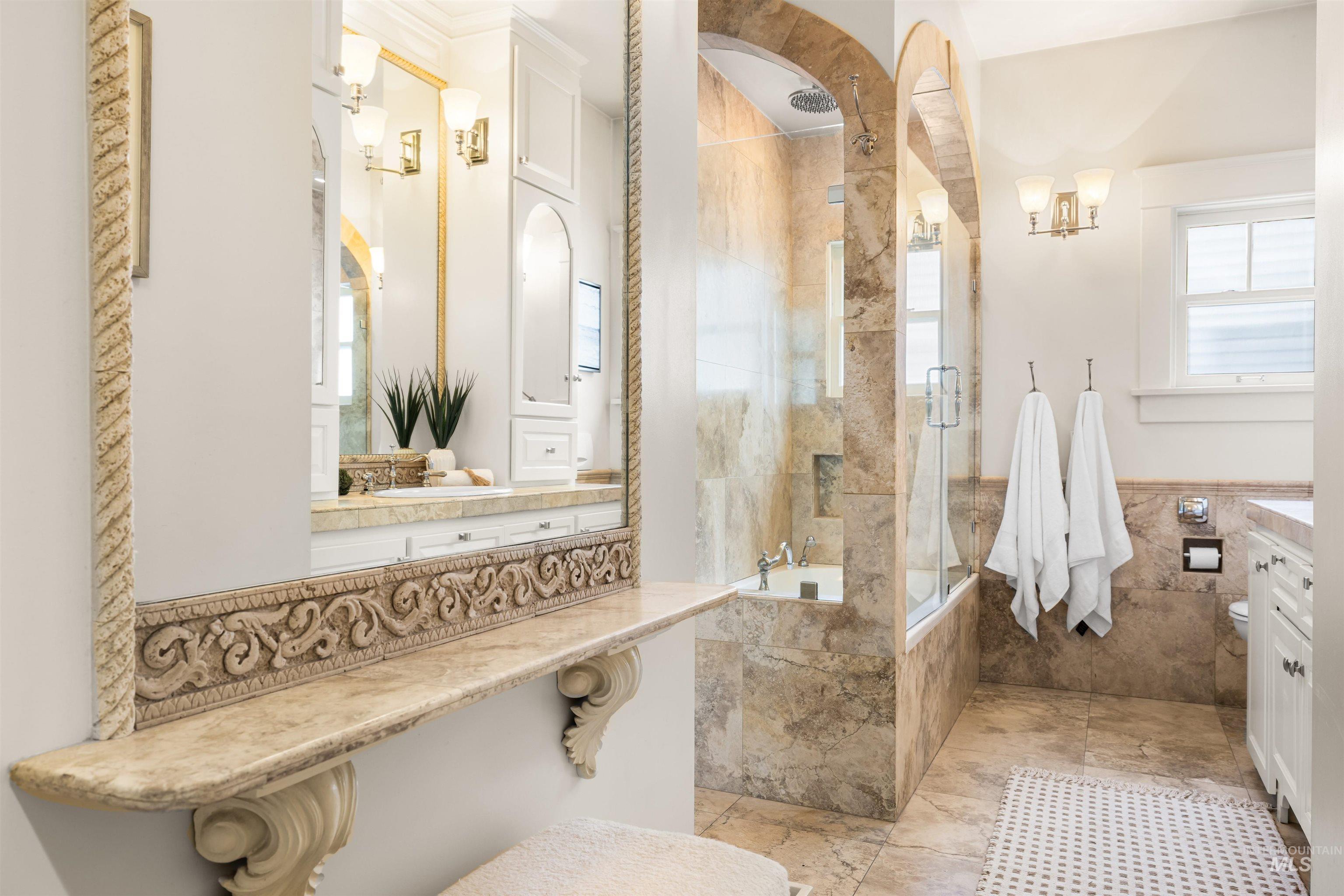 Full bathroom featuring vanity, a combined bath / shower with rainfall shower, and tile walls