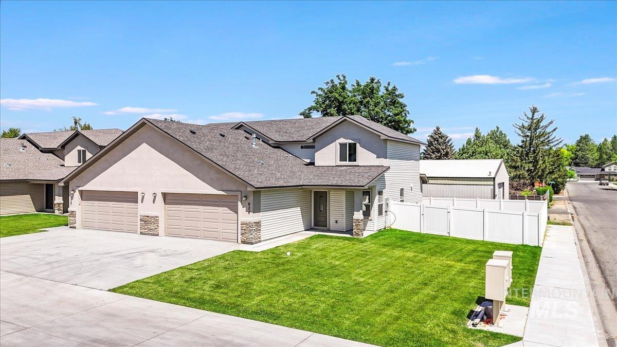 Traditional home featuring stone siding, roof with shingles, stucco siding, driveway, and a garage