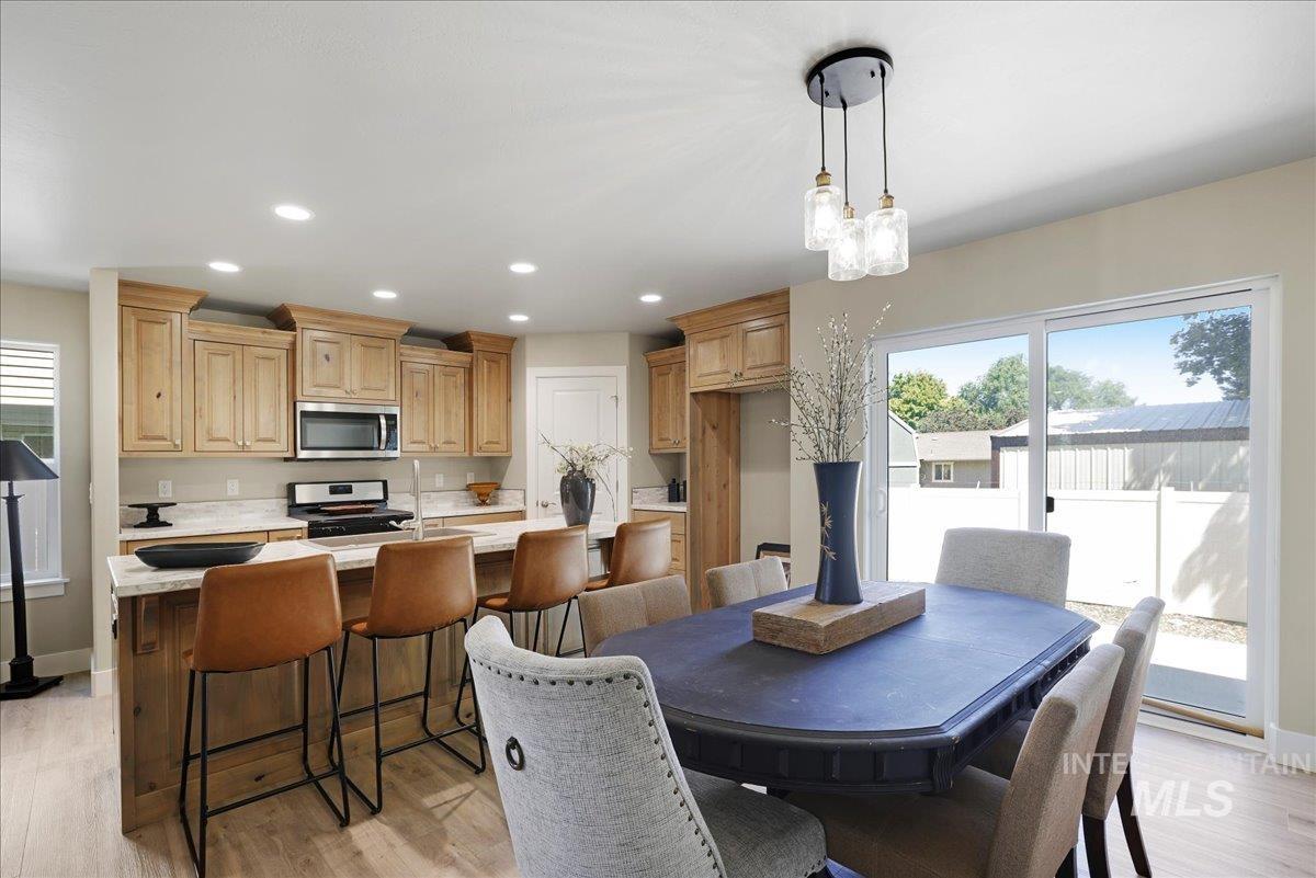 Dining area featuring plenty of natural light, light wood-type flooring, recessed lighting, and a chandelier