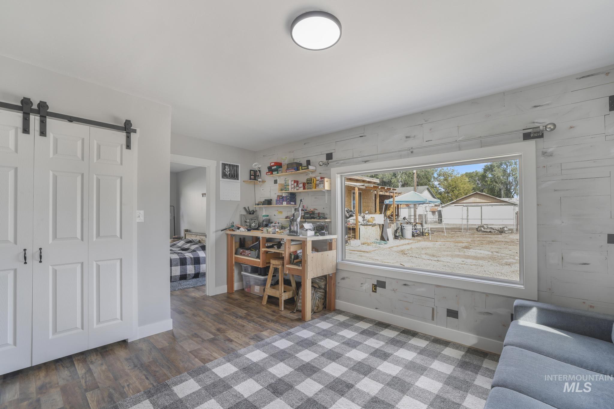 Living room with a barn door and wood finished floors