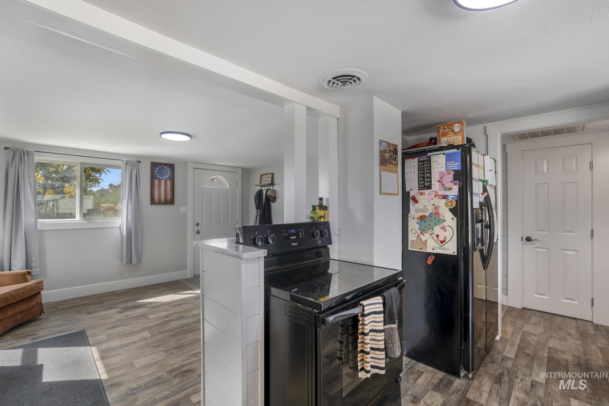 Kitchen featuring black appliances and wood finished floors