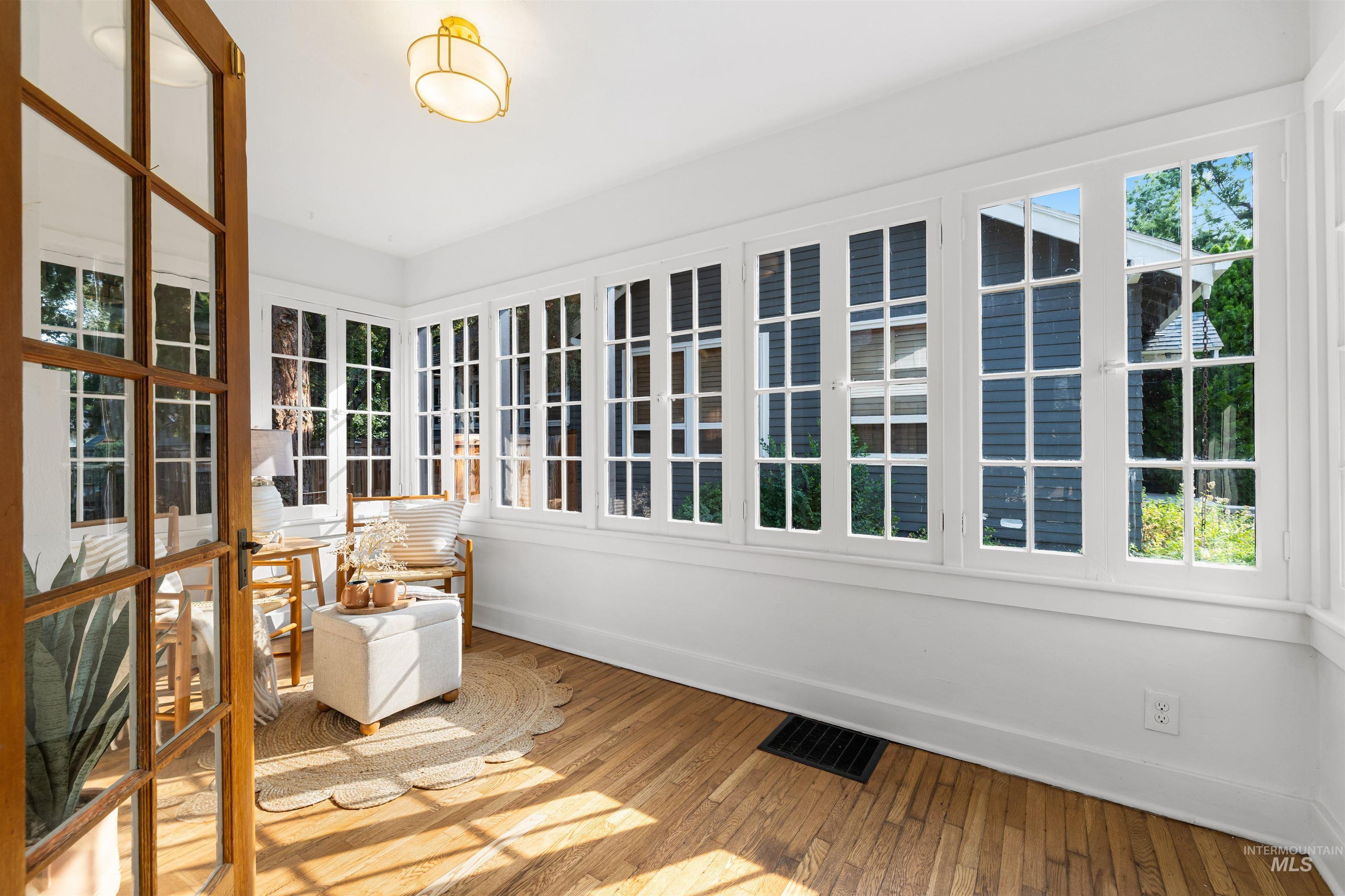 Unfurnished sunroom with plenty of natural light and hardwood / wood-style flooring