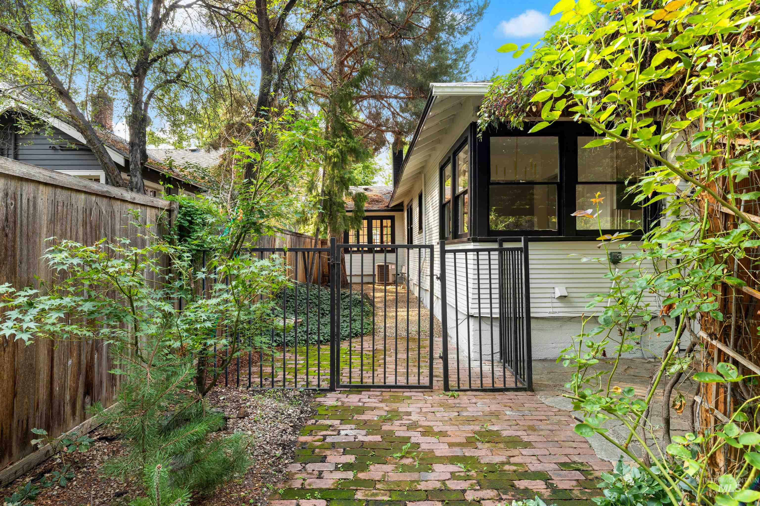 Gate with a patio area and a sunroom
