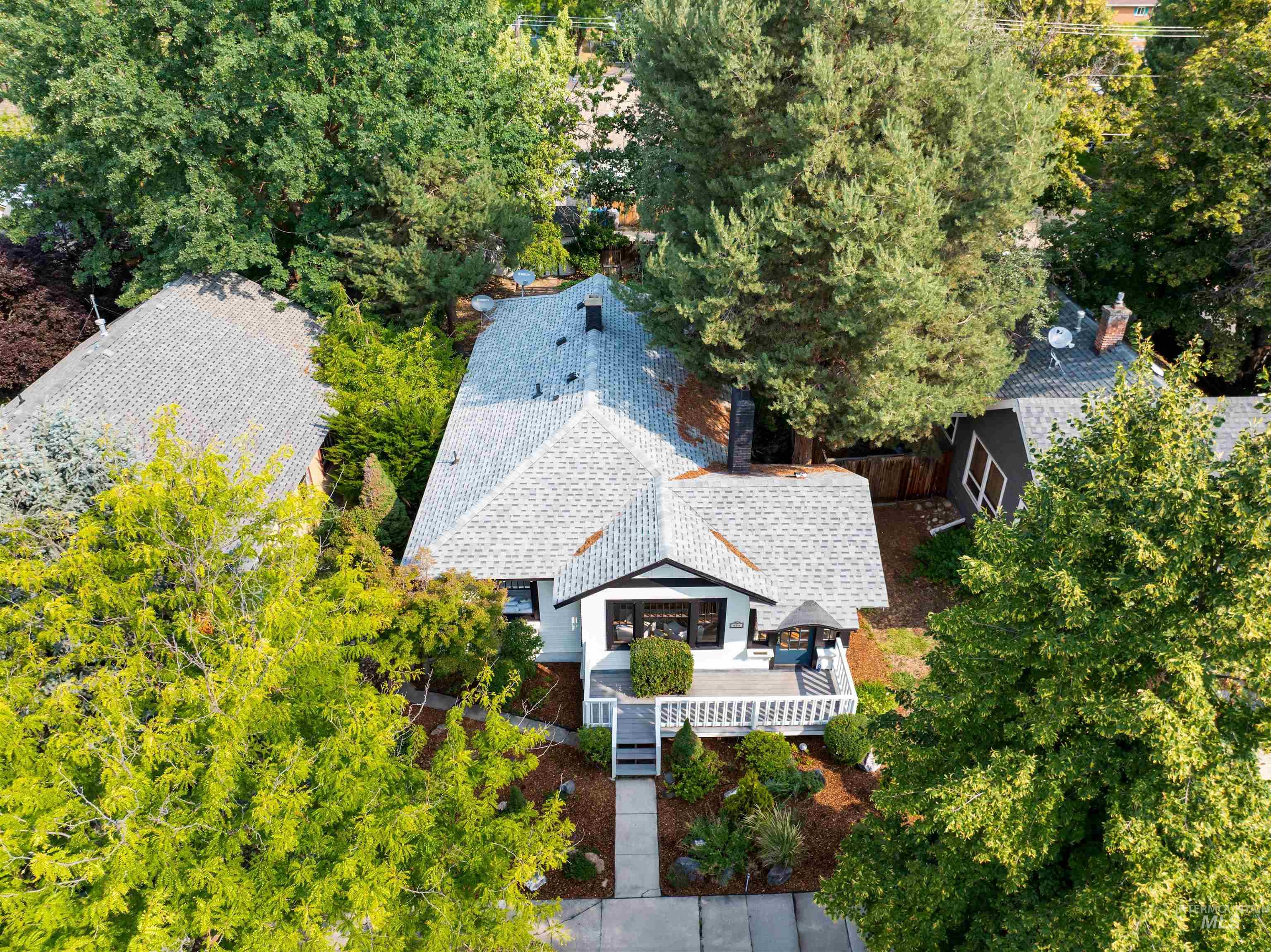Aerial view of property and surrounding area featuring a tree filled landscape