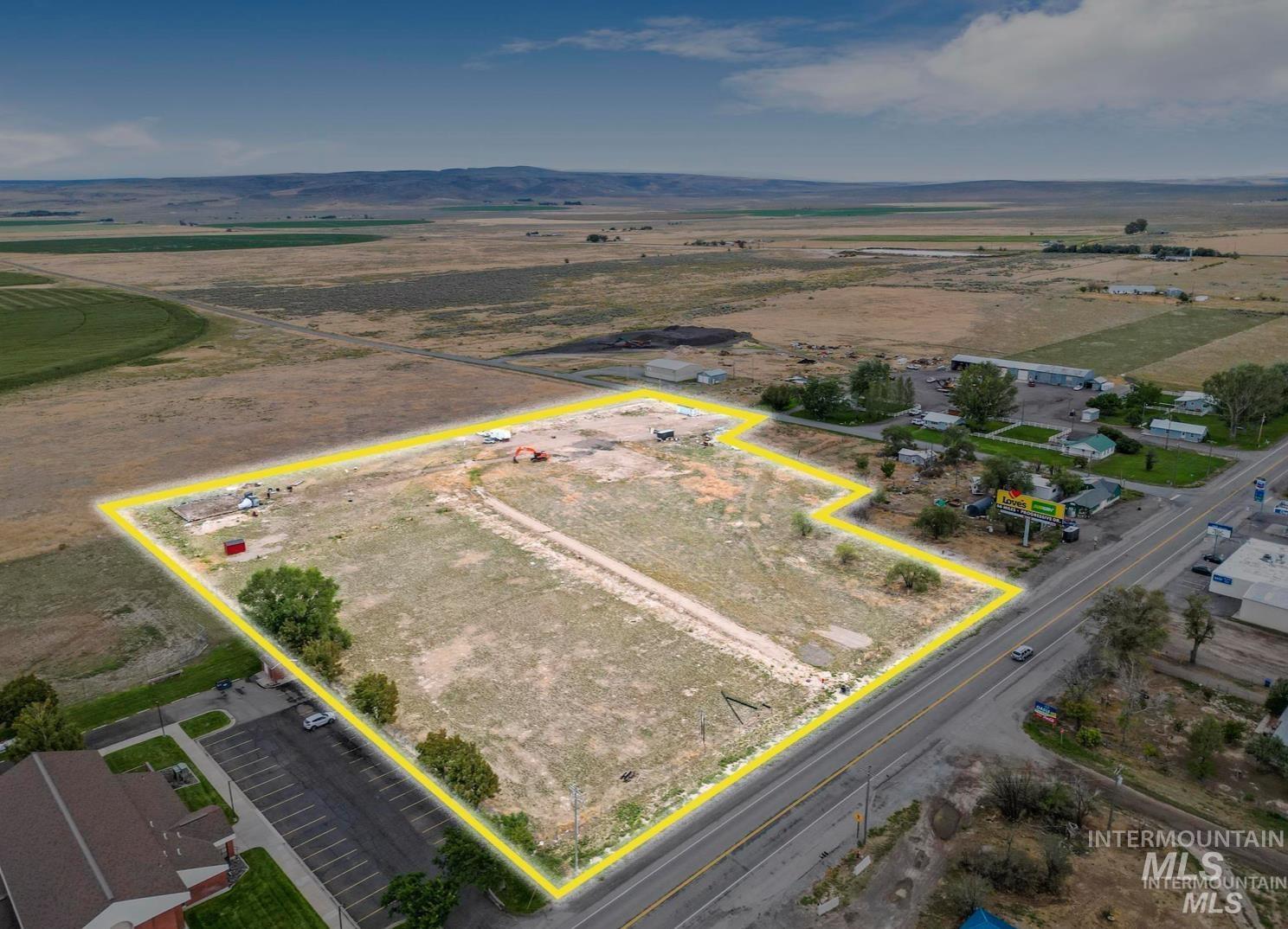 Overview of rural landscape with property parcel outlined and a mountain backdrop
