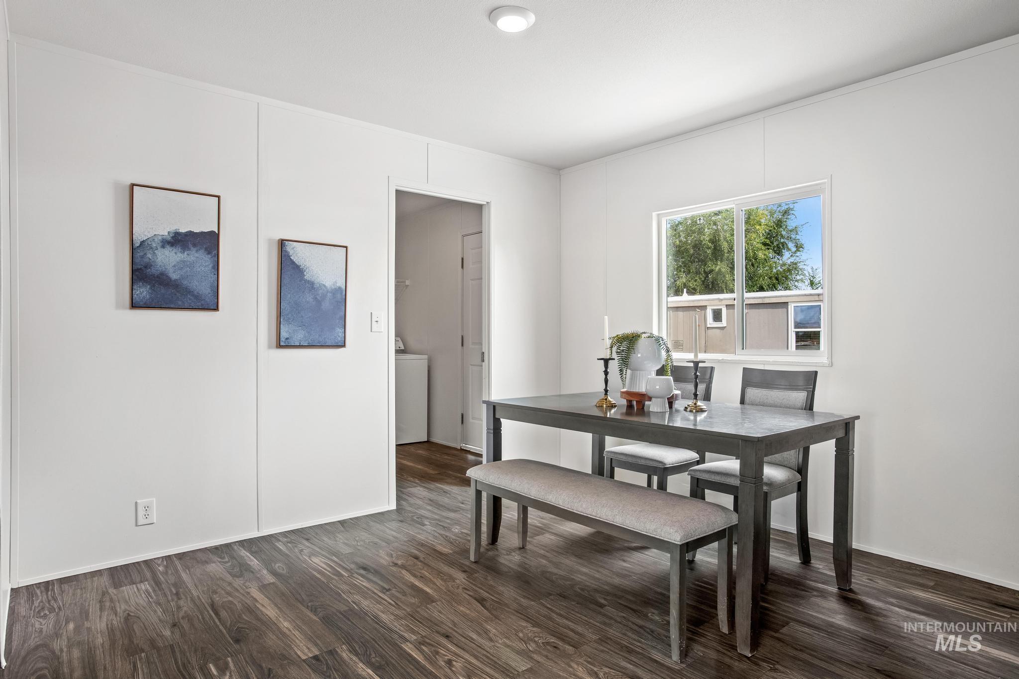 Dining area featuring dark wood-style flooring and baseboards