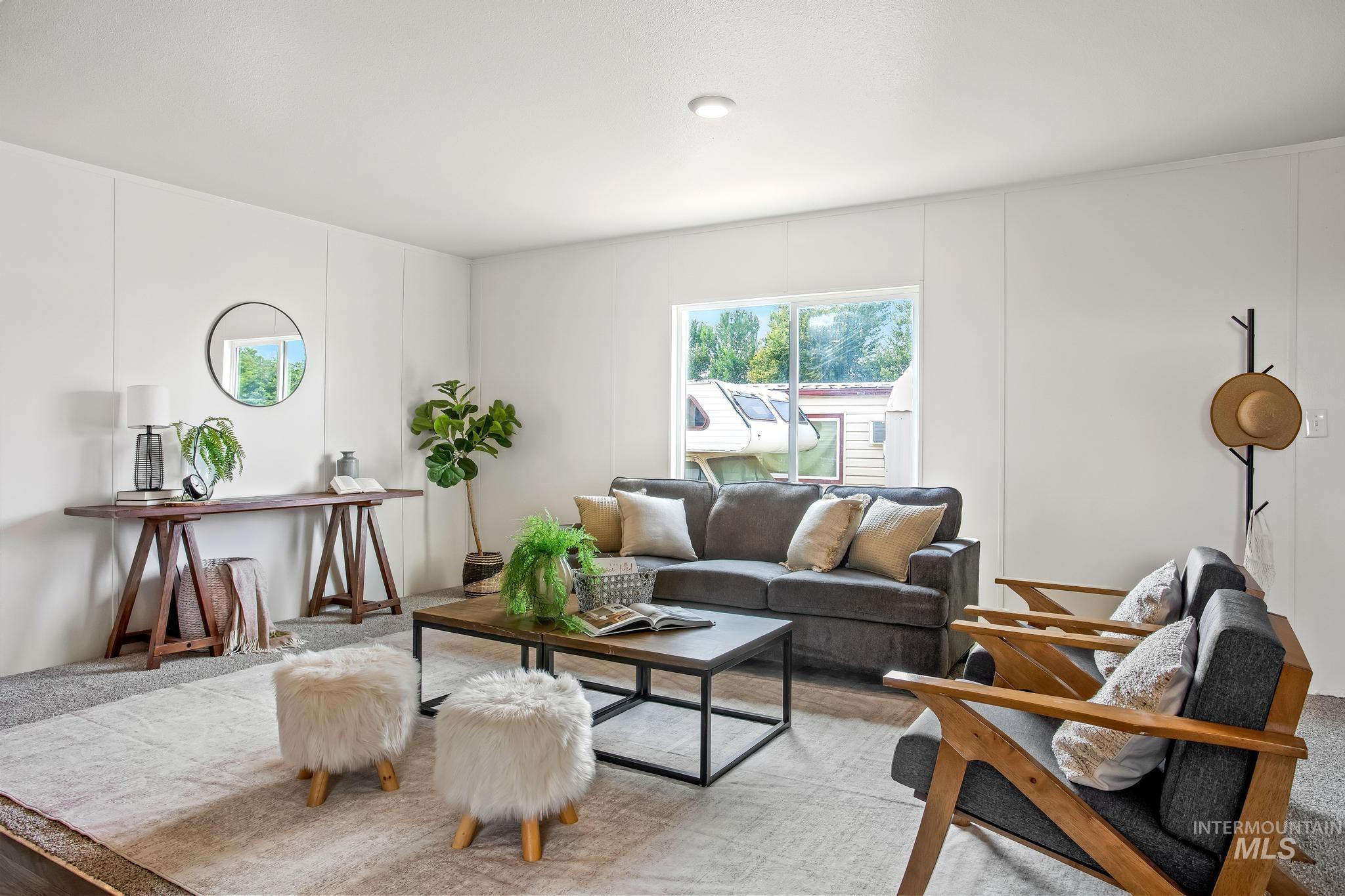 Carpeted living room featuring a decorative wall