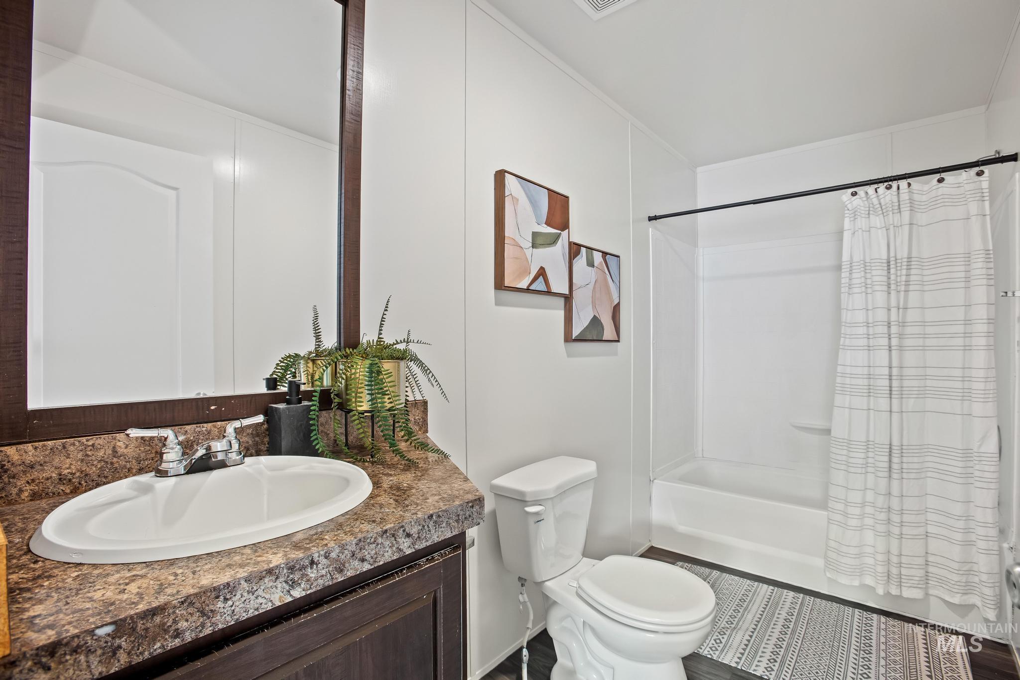 Bathroom featuring vanity and shower / bath combination with curtain