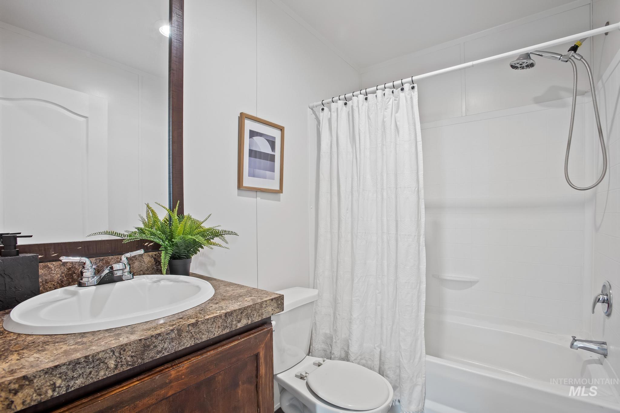 Full bath with shower / tub combo with curtain and vanity