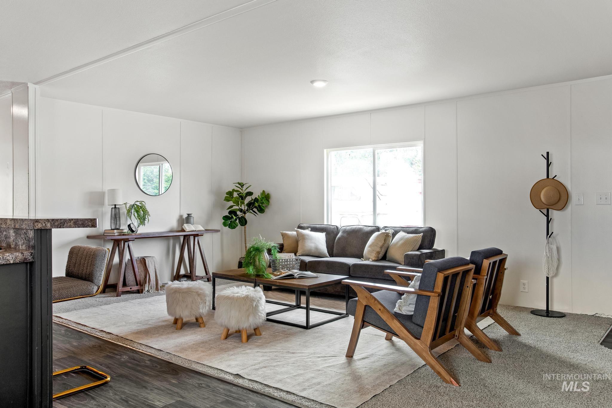 Carpeted living room featuring healthy amount of natural light and a decorative wall