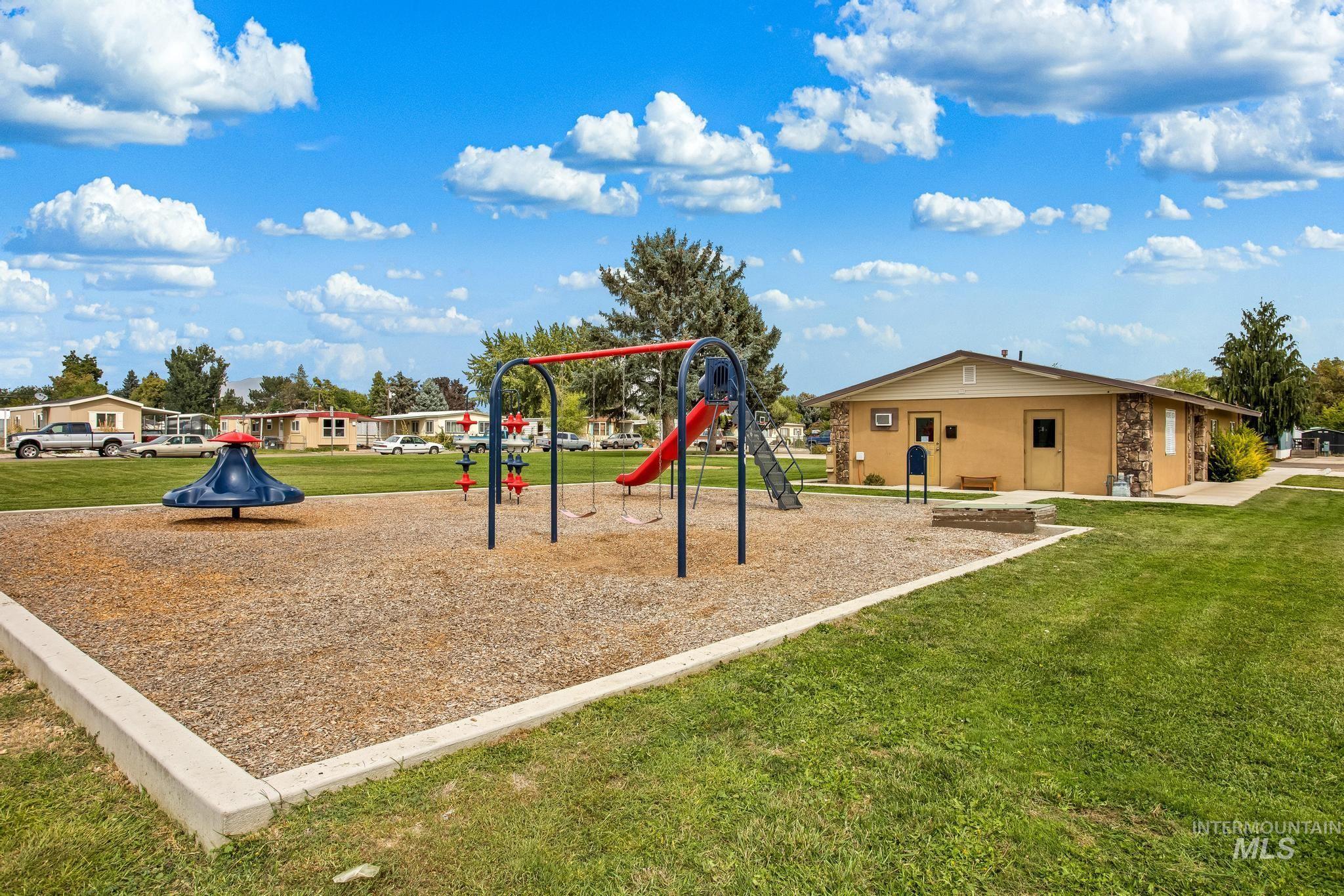 Community playground featuring a lawn and a residential view