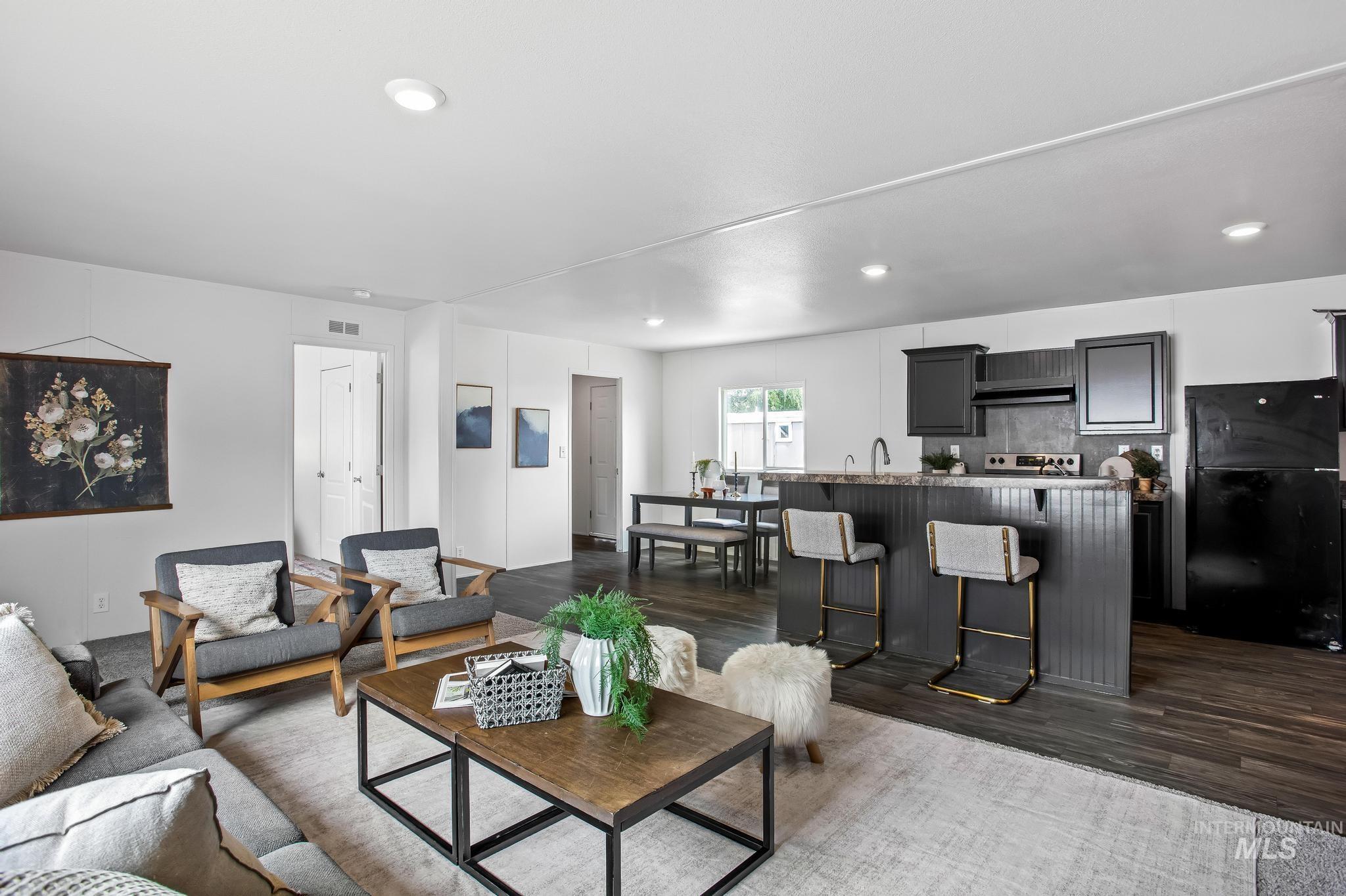 Living area with dark wood finished floors and recessed lighting