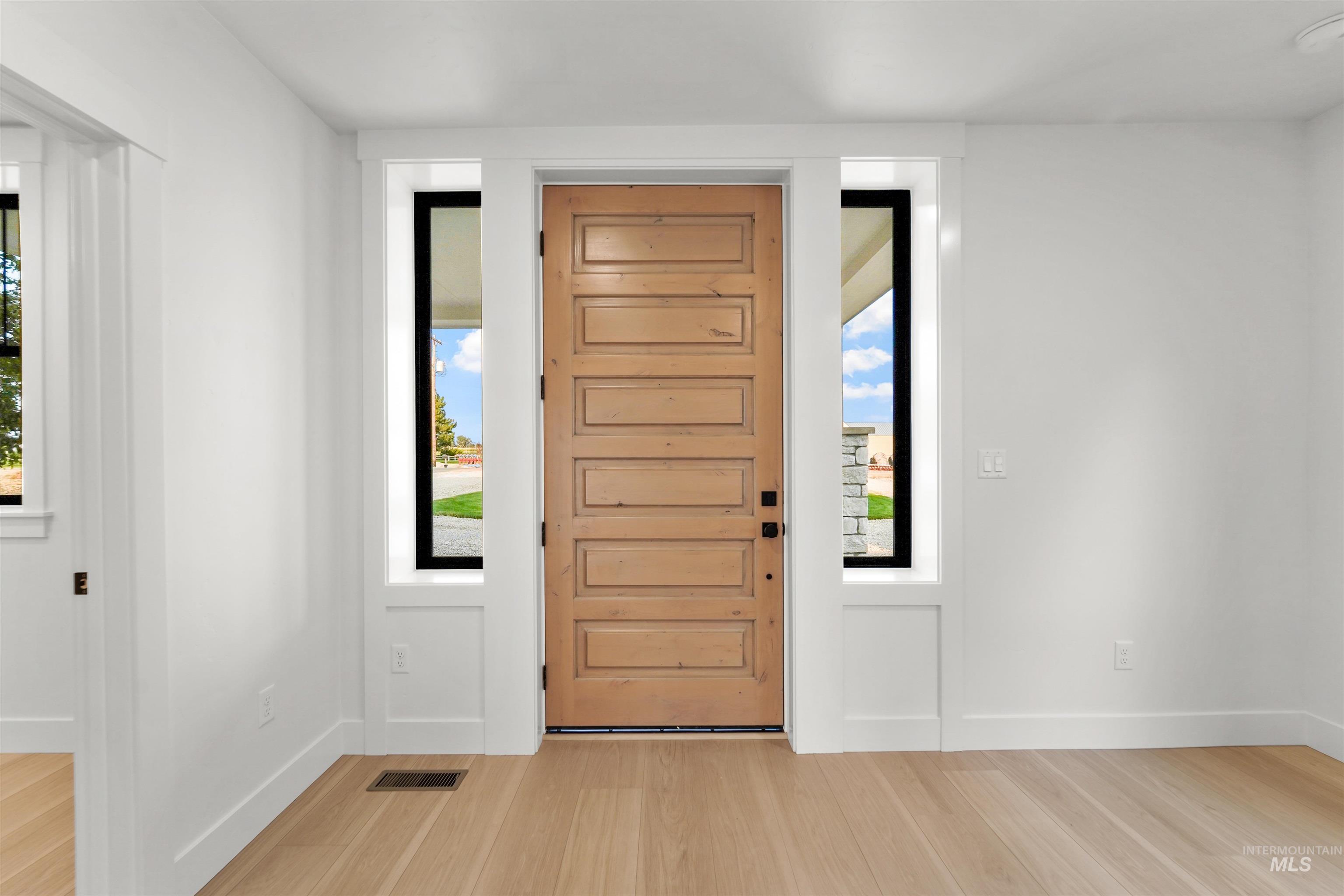 Foyer featuring light wood-style floors and baseboards