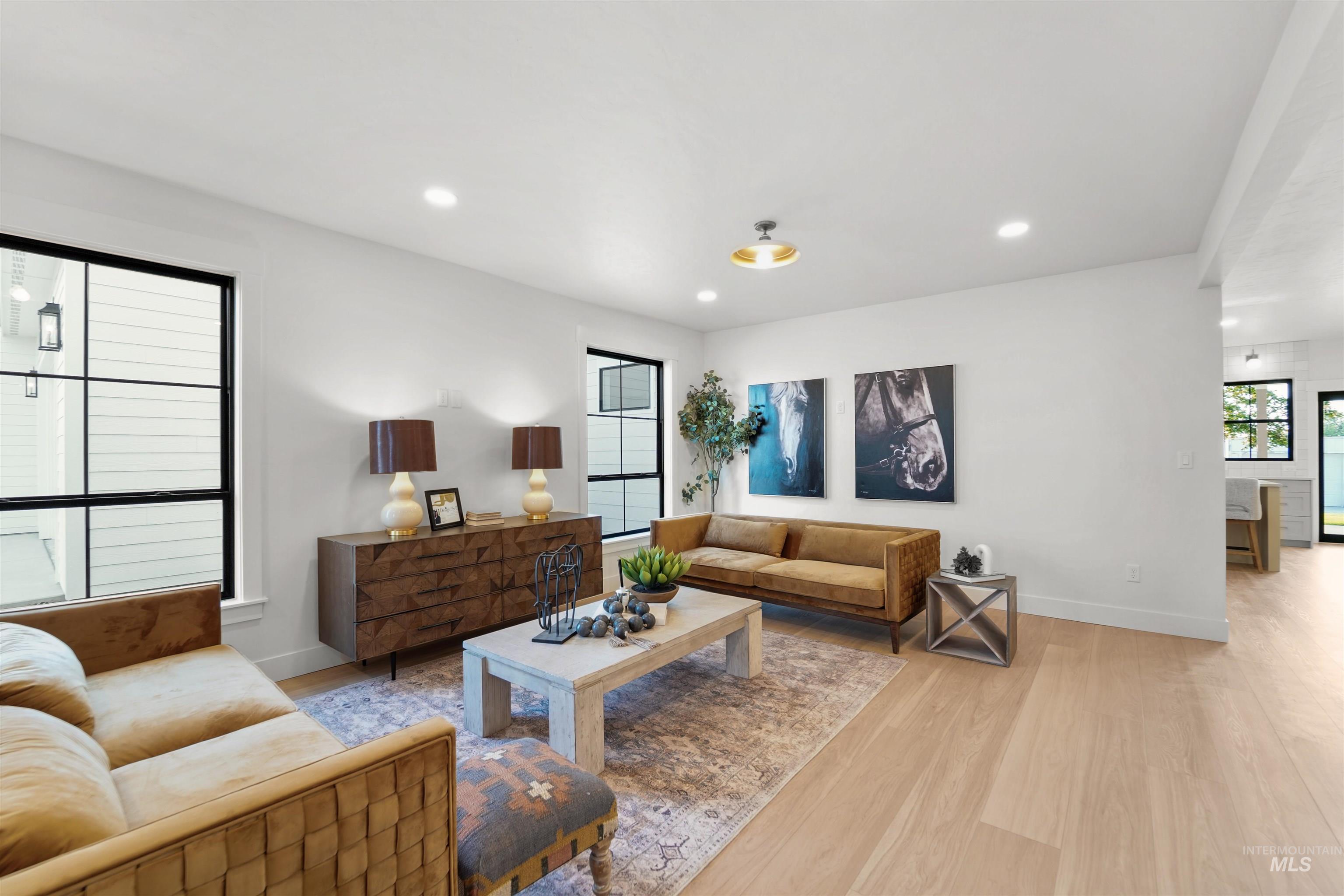 Living area with light wood finished floors and recessed lighting