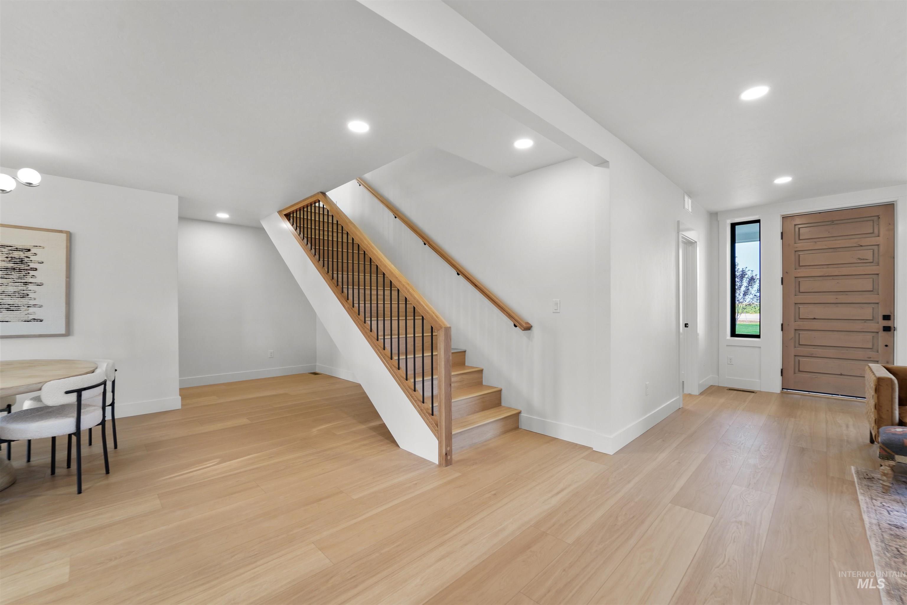 Entrance foyer with recessed lighting, stairway, and light wood-type flooring