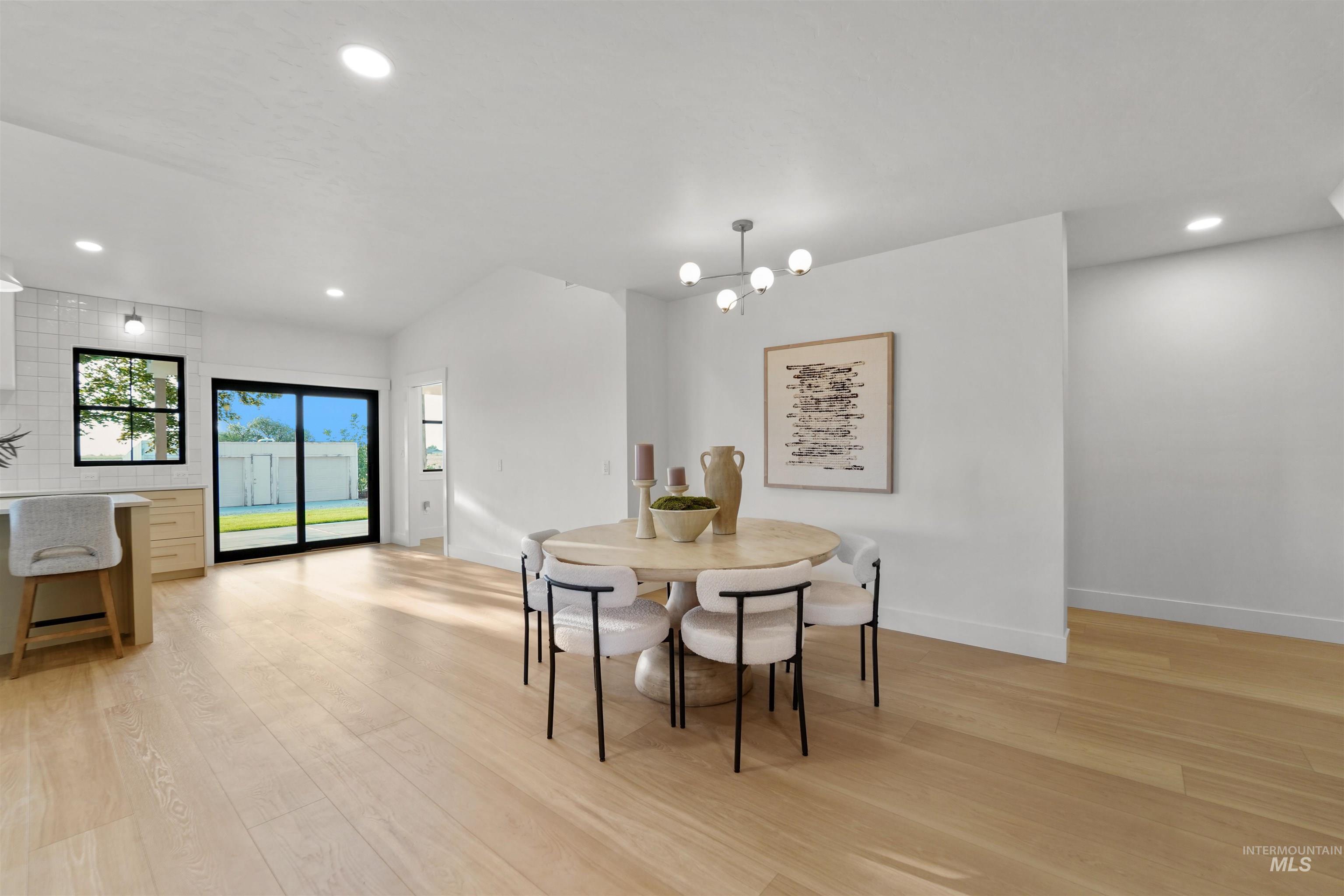Dining room with recessed lighting, light wood-type flooring, and a chandelier