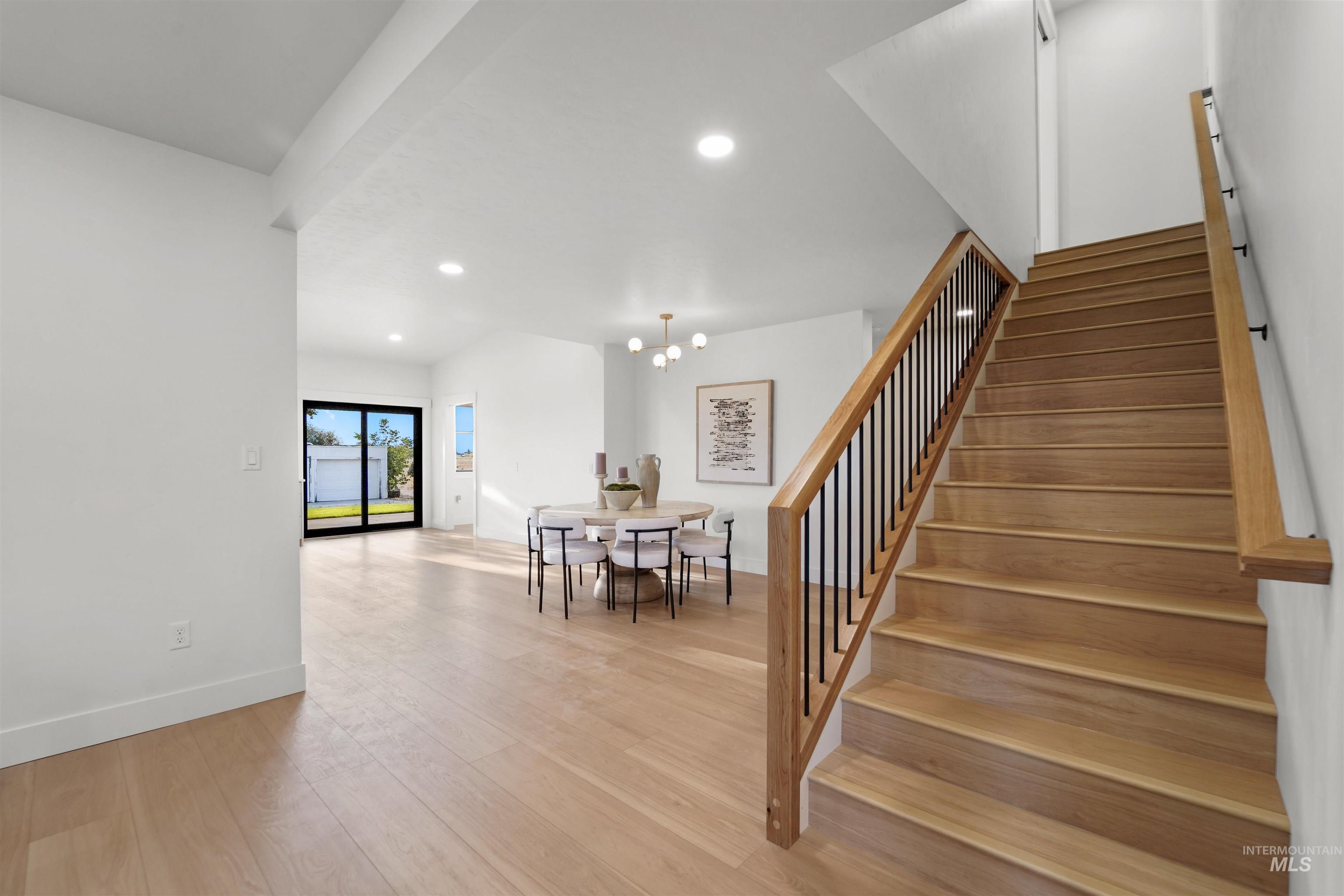 Stairs with wood finished floors, recessed lighting, and a chandelier