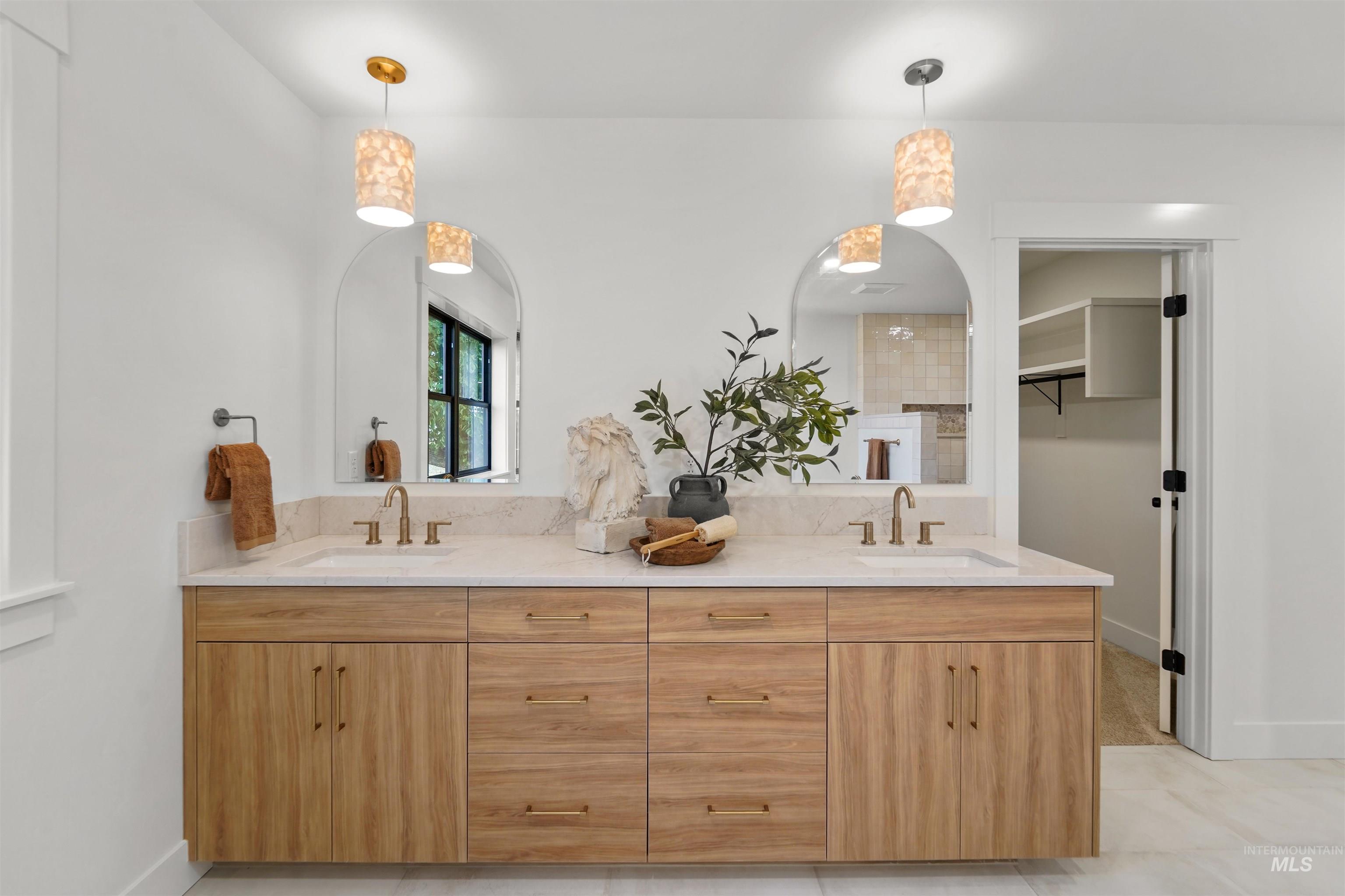 Full bath featuring double vanity and light tile patterned floors