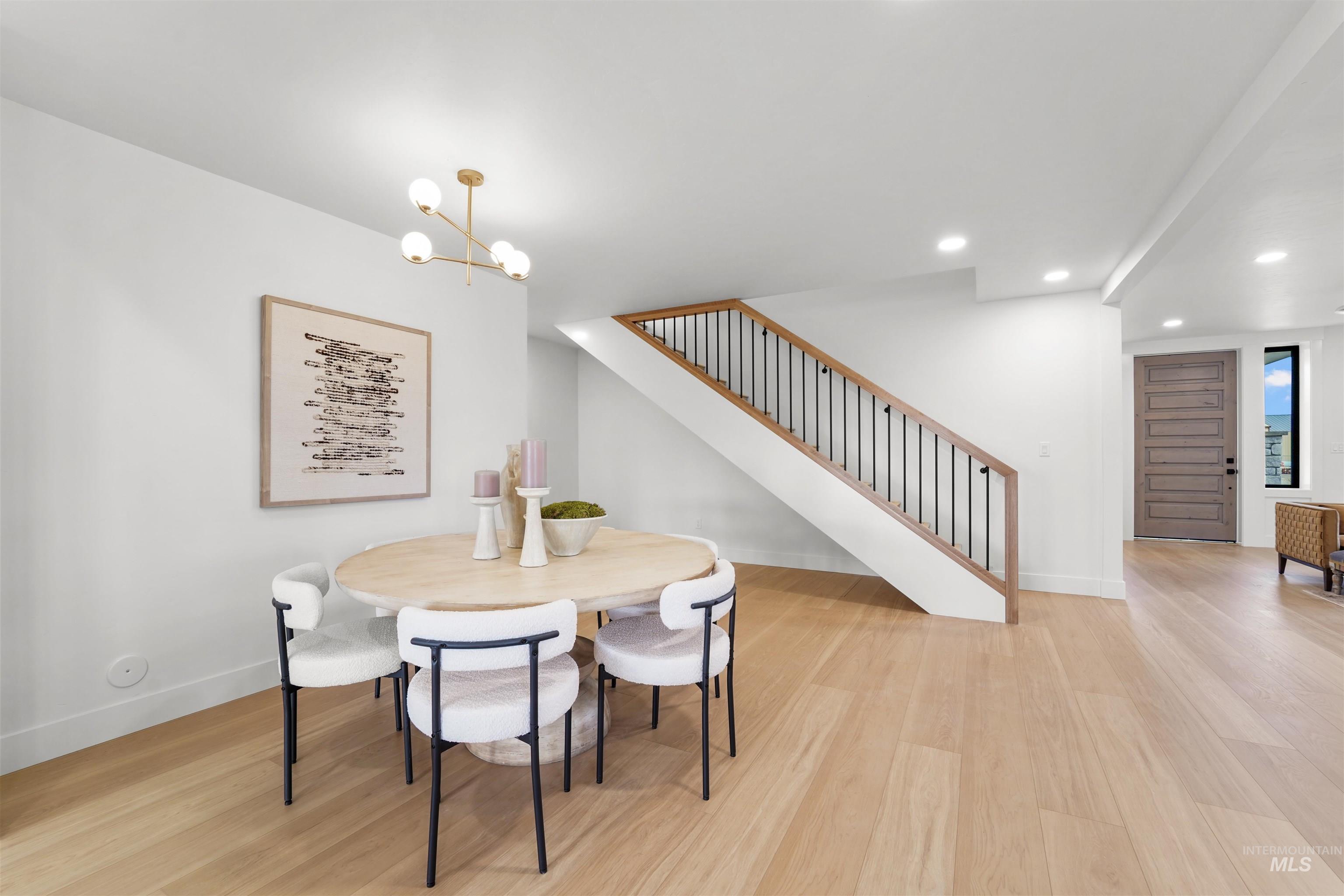 Dining area with stairway, recessed lighting, a chandelier, and light wood-style flooring