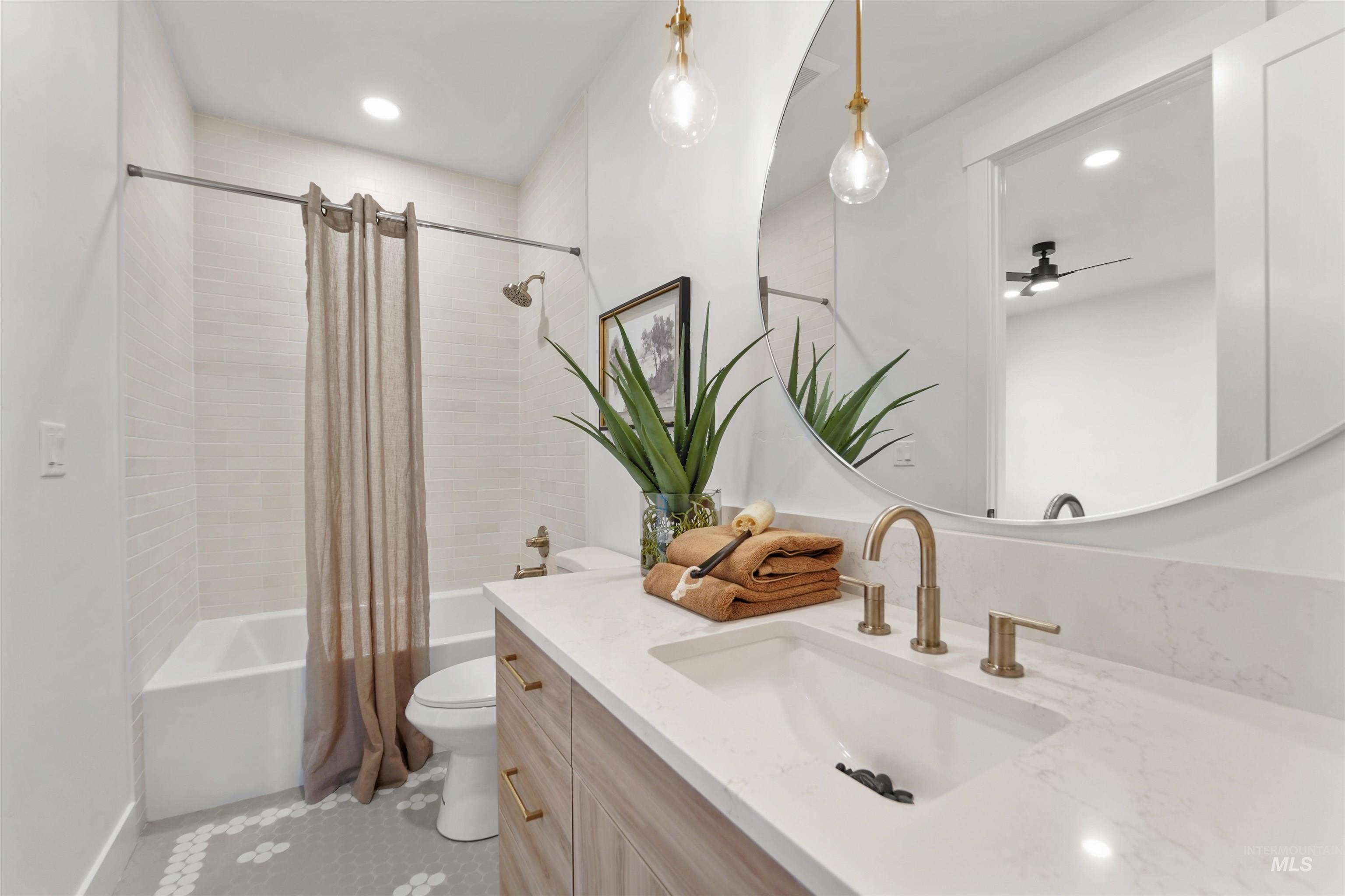 Full bathroom featuring shower / bath combo with shower curtain, vanity, recessed lighting, and light tile patterned flooring