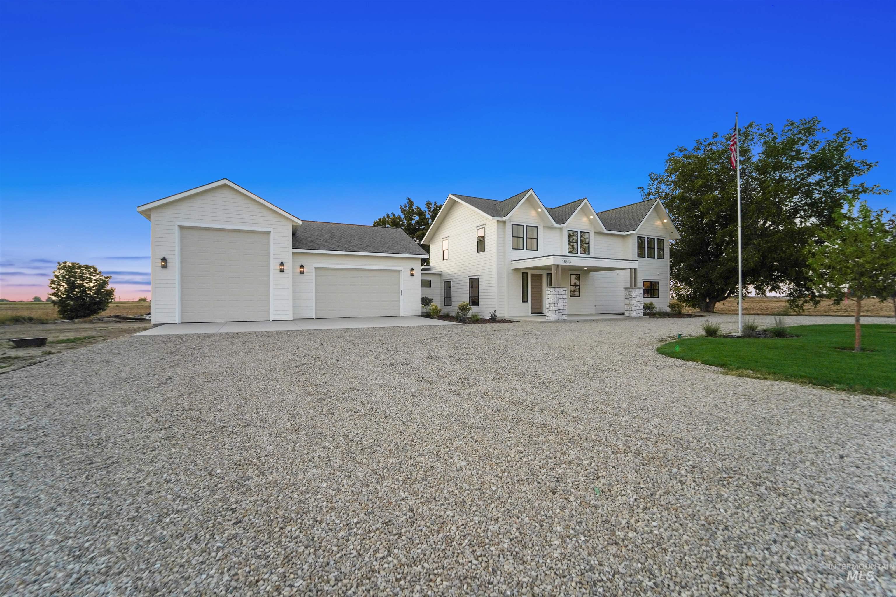 Traditional home with a porch, driveway, and a shingled roof