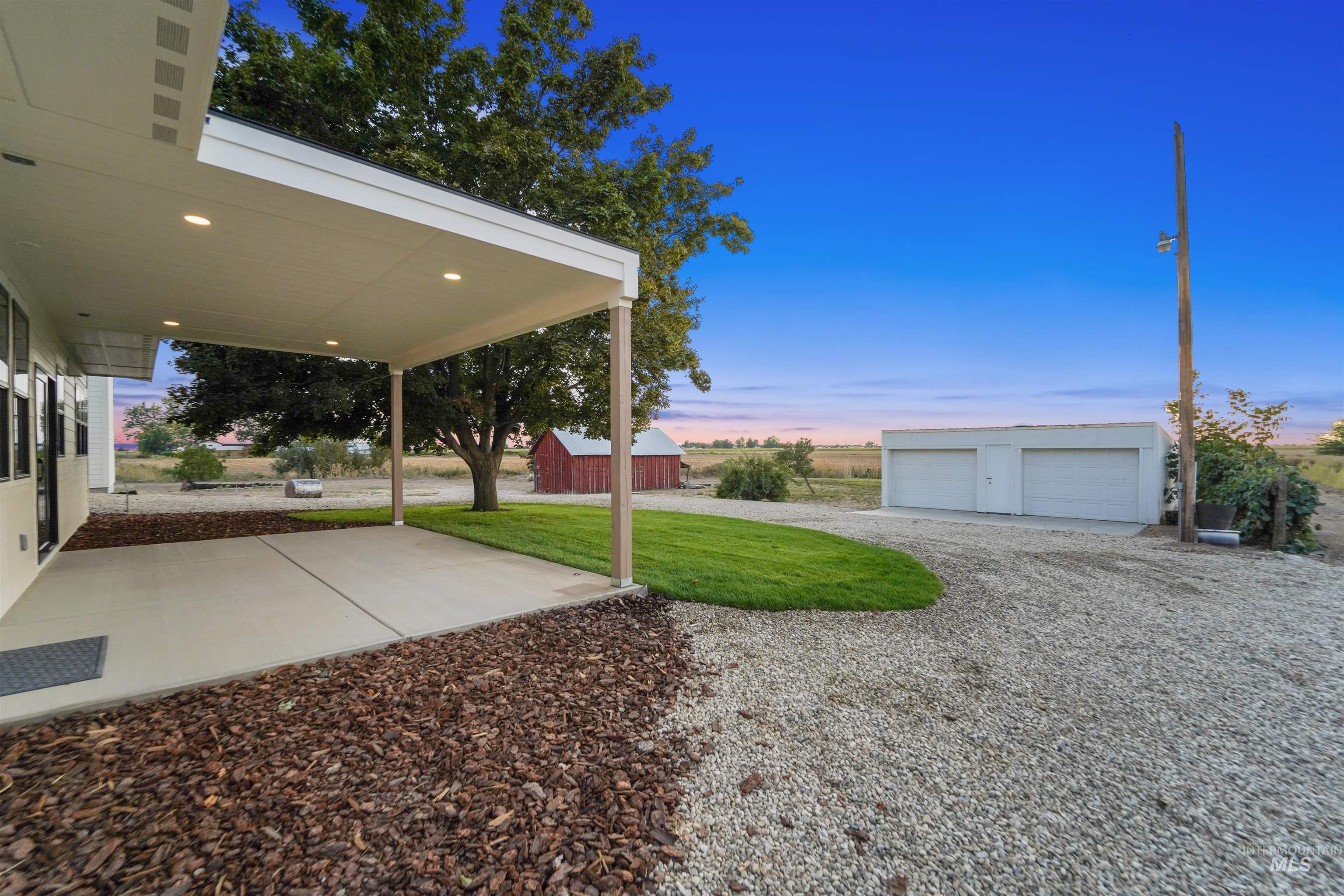 Yard at dusk featuring an outdoor structure and a lawn
