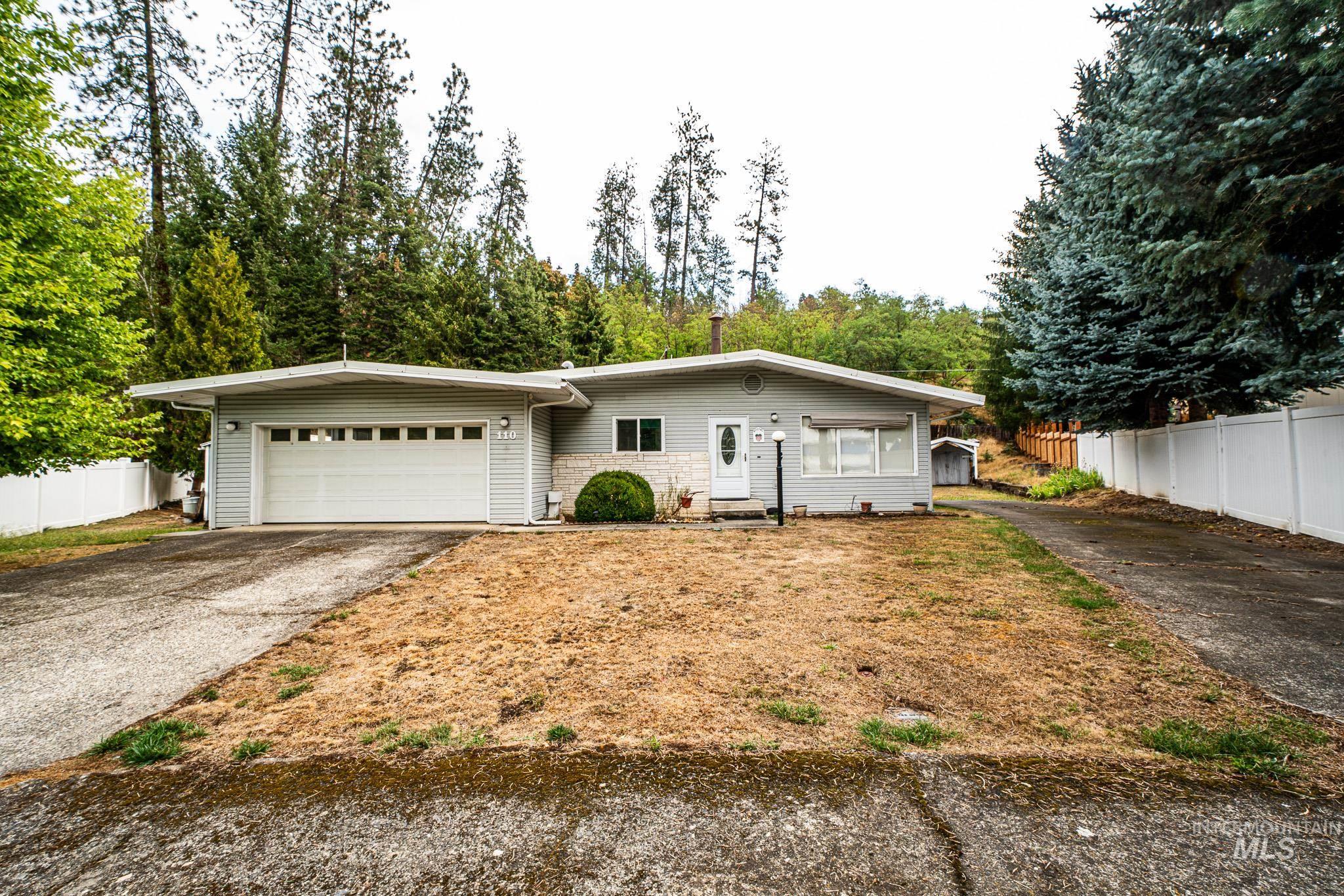 View of front of house with asphalt driveway and an attached garage