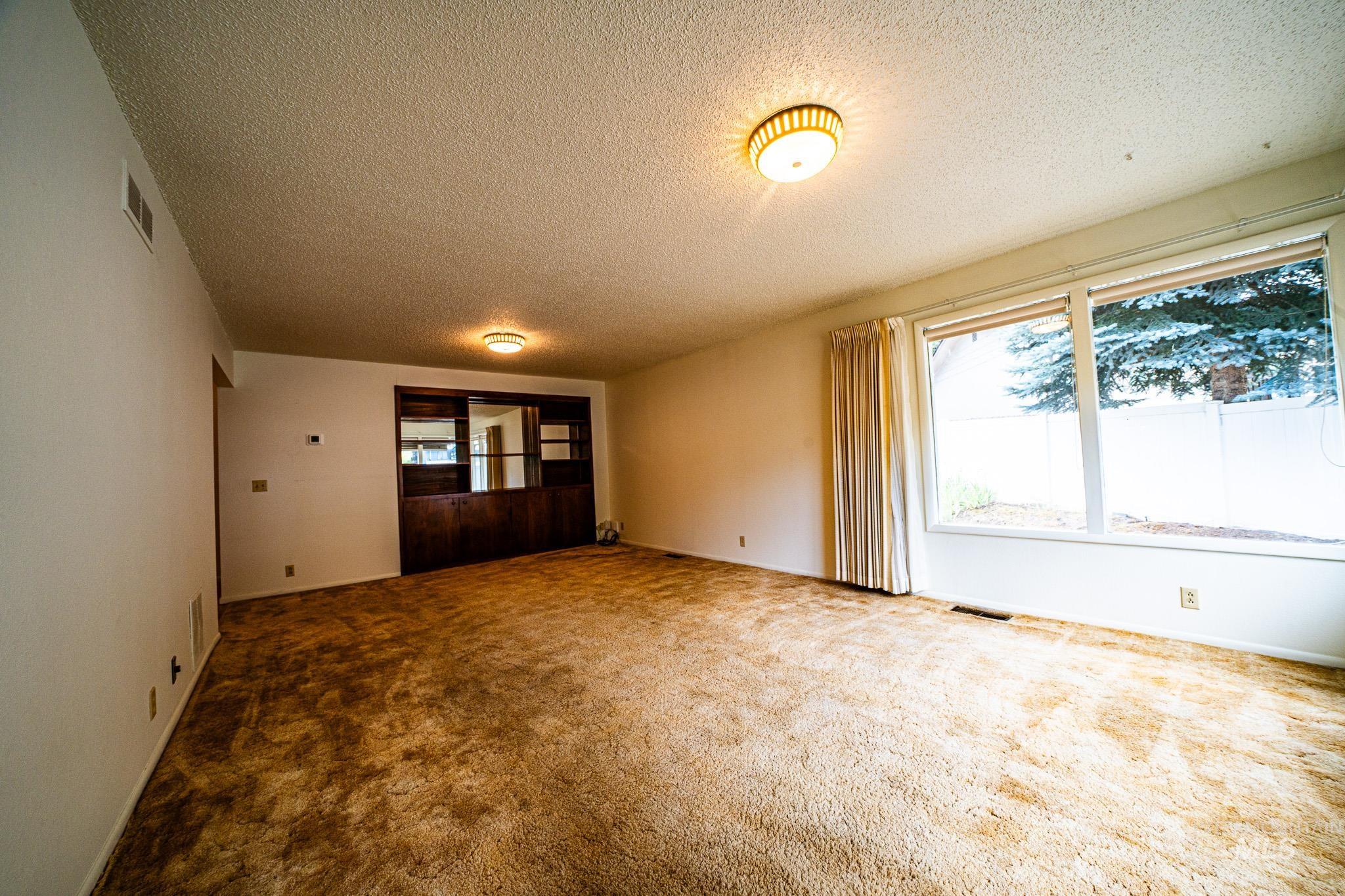 Unfurnished dining area featuring a textured ceiling and carpet flooring