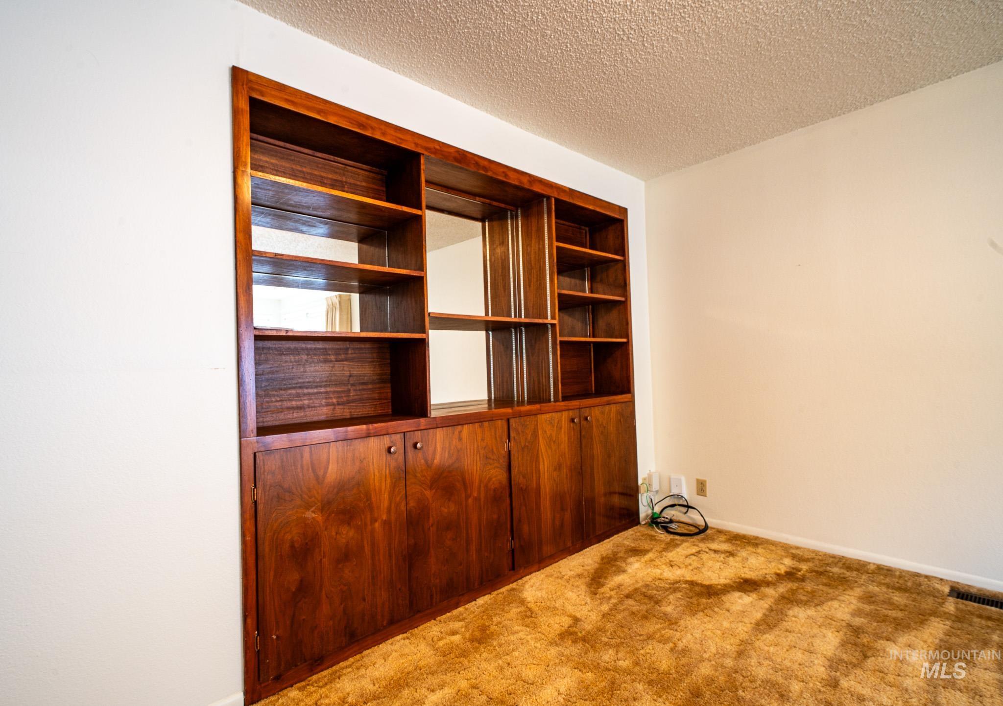 Interior space featuring a textured ceiling and baseboards
