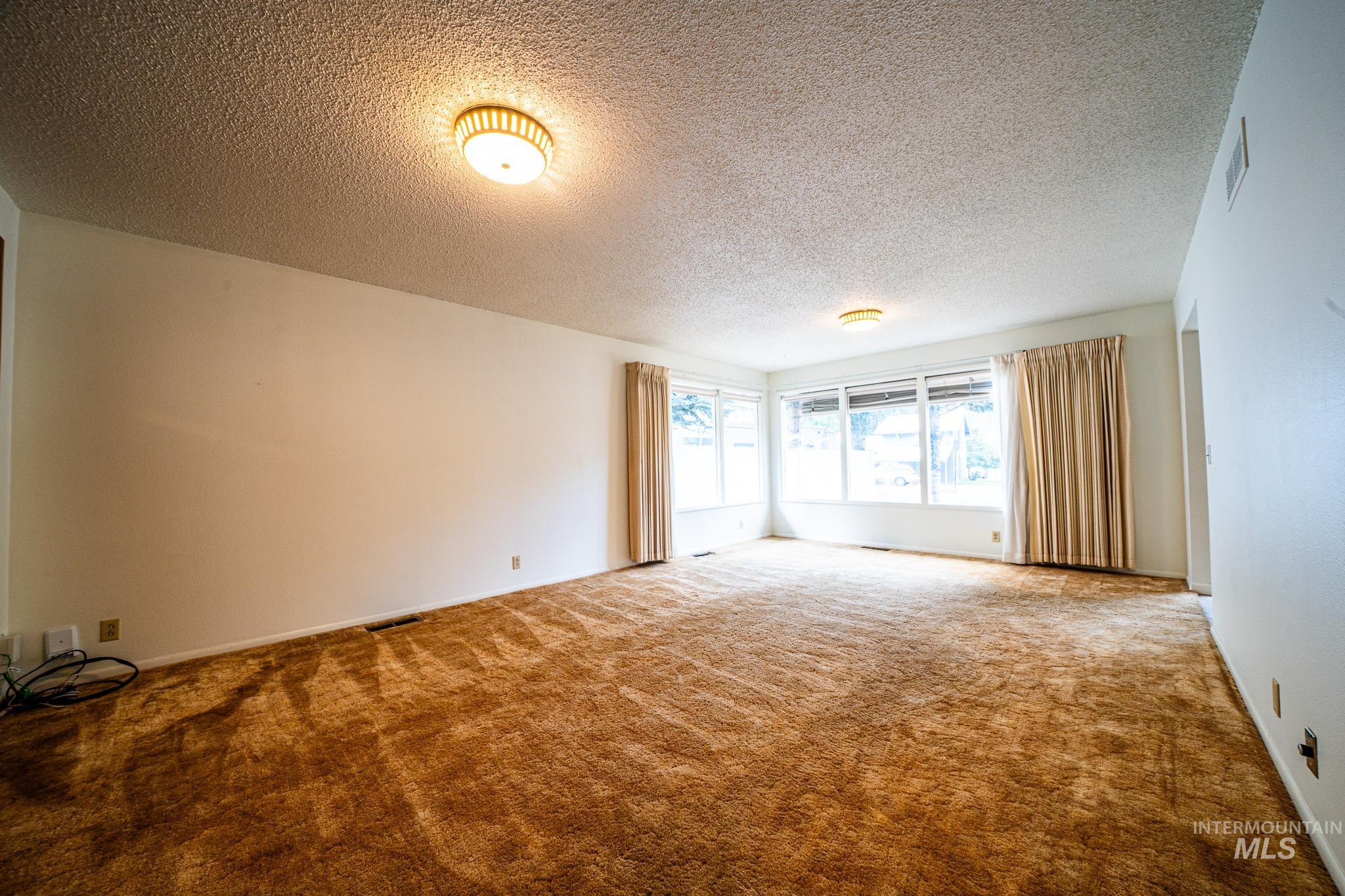 Spare room with a textured ceiling and carpet flooring